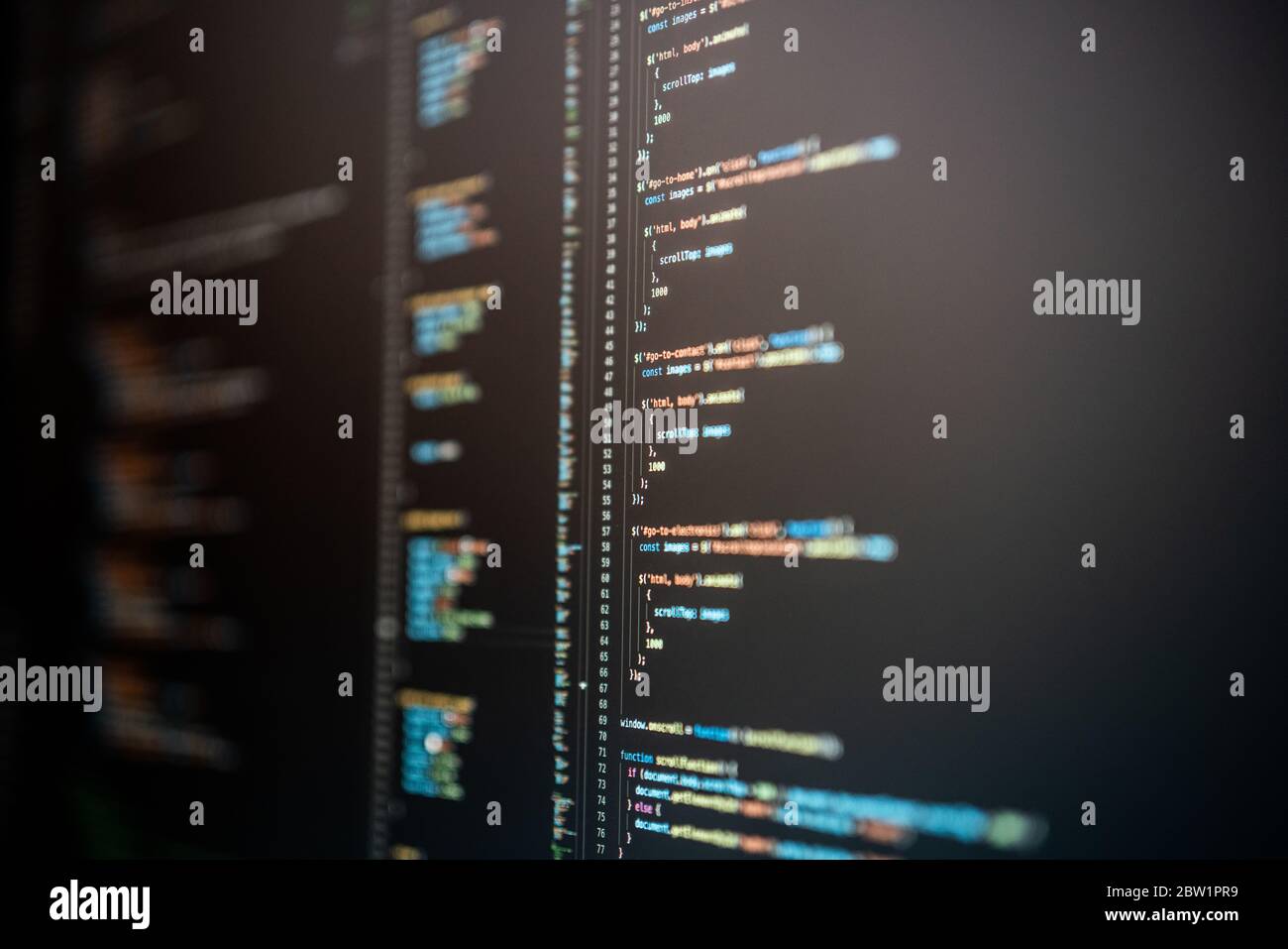 JavaScript-Code in verschiedenen Farben auf einem dunklen Computerbildschirm. Stockfoto