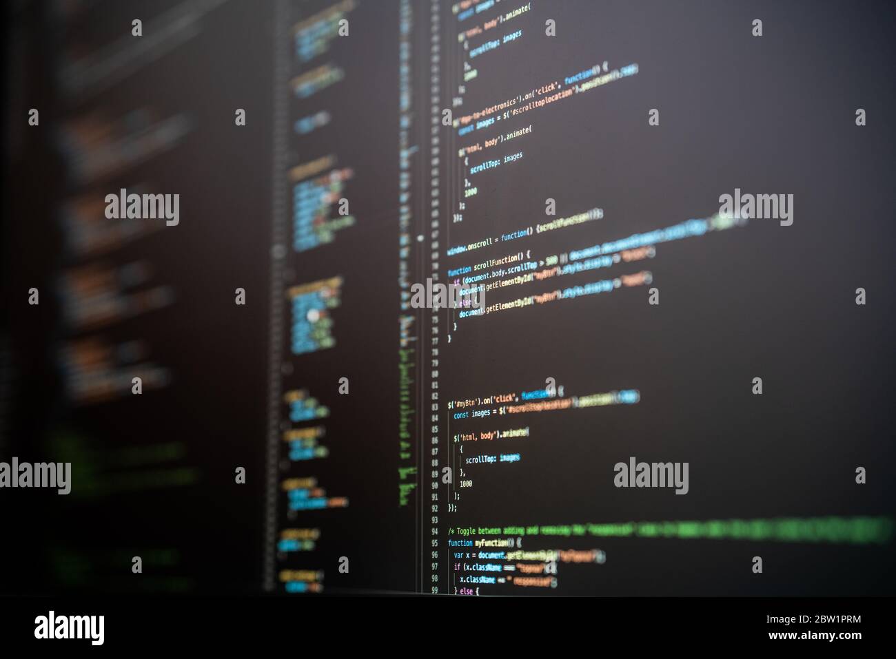 JavaScript-Code in verschiedenen Farben auf einem dunklen Computerbildschirm. Stockfoto