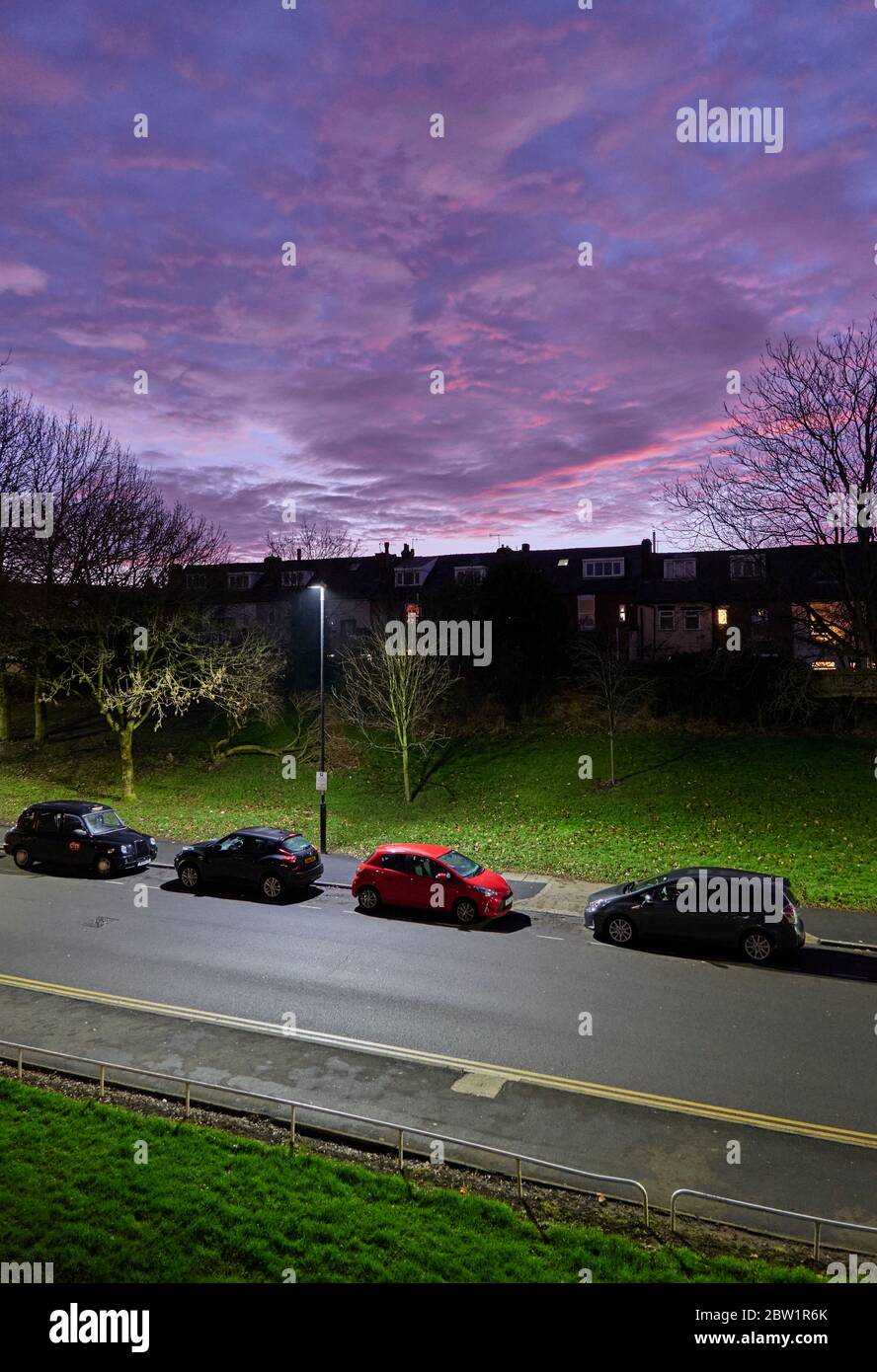 Lila Himmel und Wolken bei Sonnenuntergang kontrastieren mit grünem Gras an der Seite der Washington Road, Sheffield Stockfoto