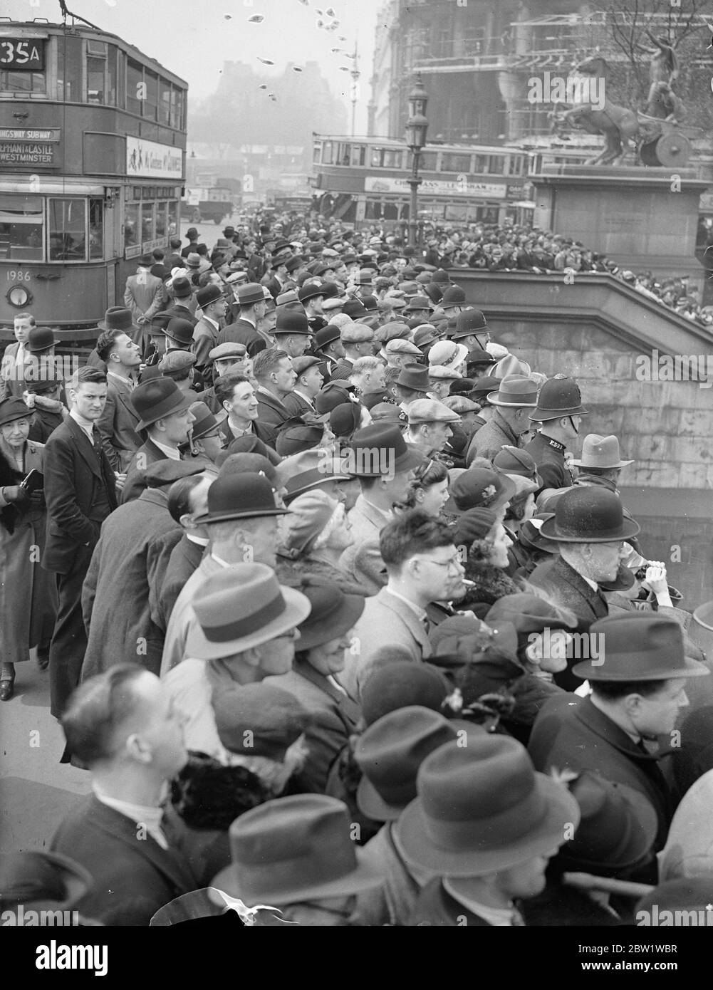 Menschenmassen warten darauf, King und Queen in Westminster zu sehen. Große Menschenmengen versammelten sich auf der Westminster Bridge, um zu sehen, wie der König und die Königin auf dem Royal Barge nach Greenwich einschiffen, wo sie das neue National Maritime Museum eröffnen werden. Foto zeigt: Die große Menschenmenge auf der Westminster Bridge wartet auf den König und die Königin. 27. April 1937 Stockfoto