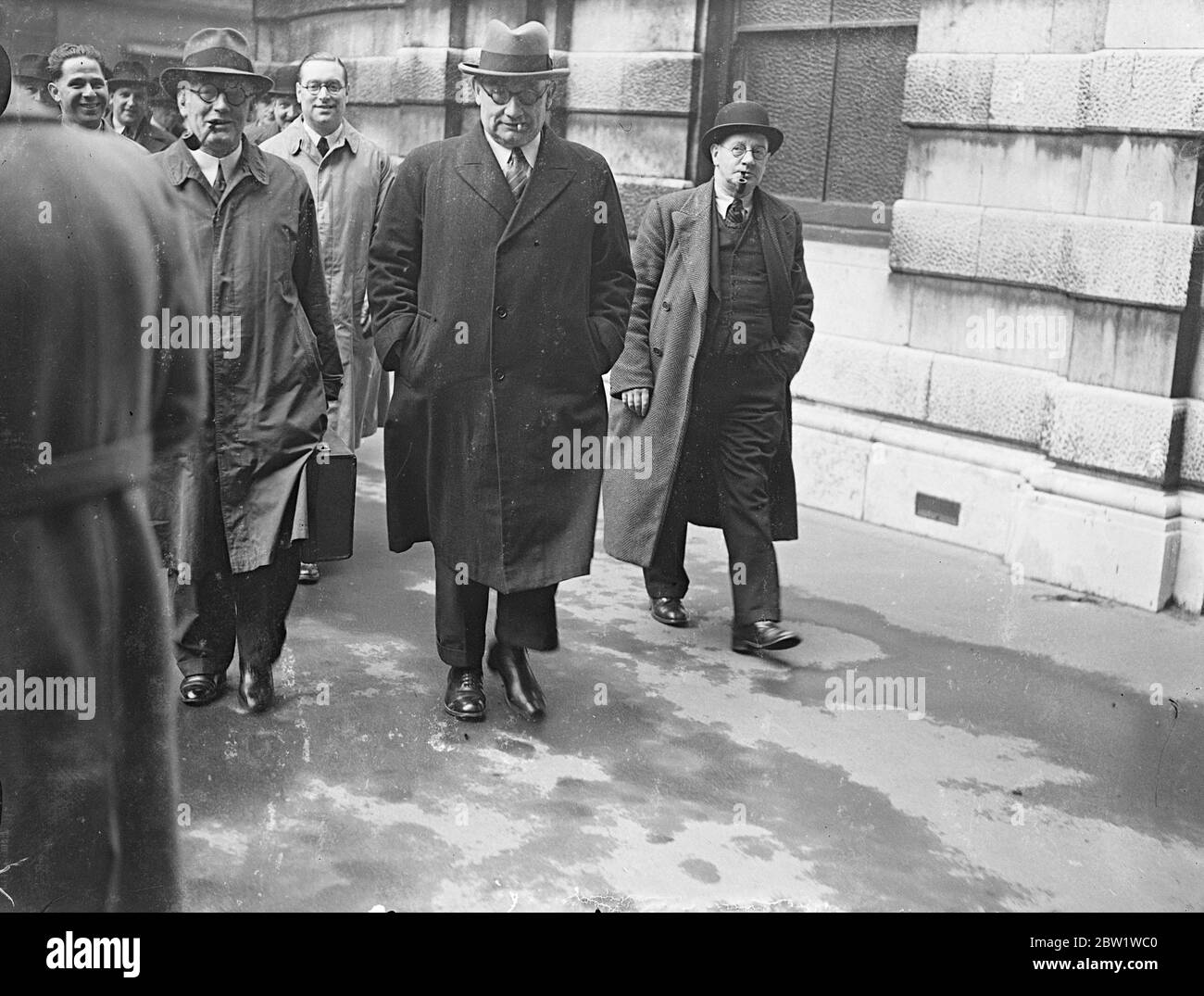 Beamte treffen sich zu einer kritischen Diskussion im Busstreit. Das Central Bus Committee und die Londoner Verkehrsbeamten trafen sich im Arbeitsministerium zu ihrer kritischen Konferenz über den Busstreit. Sollte es bei diesen Gesprächen nicht zu einer zufriedenstellenden Lösung des Streits kommen, in dem die Busleute auf einen 7 1/2-Stunden-Tag drängen, droht um Mitternacht (Freitag) ein Generalstreik. Foto zeigt: Ernest Bevin, Vorsitzender der T.U. C. (Mitte) und Harold Clay, (links) nationaler Sekretär der Passagiergruppenunion, kommen mit anderen Mitgliedern zu den kritischen Diskussionen. 28. April 1937 Stockfoto