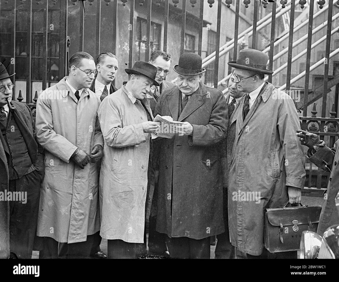Beamte treffen sich zu einer kritischen Diskussion im Busstreit. Das Central Bus Committee und die Londoner Verkehrsbeamten trafen sich im Arbeitsministerium zu ihrer kritischen Konferenz über den Busstreit. Sollte es bei diesen Gesprächen nicht zu einer zufriedenstellenden Lösung des Streits kommen, in dem die Busleute auf einen 7 1/2-Stunden-Tag drängen, droht um Mitternacht (Freitag) ein Generalstreik. Foto zeigt: Mitglieder des Zentralbuskomitees diskutieren die Situation vor dem Treffen im Arbeitsministerium. Mitte (weicher Hut, mit Papier) ist Frank Snelling, Vorsitzender des Ausschusses und Herr Jack Mills (Bowler) Lardo Stockfoto