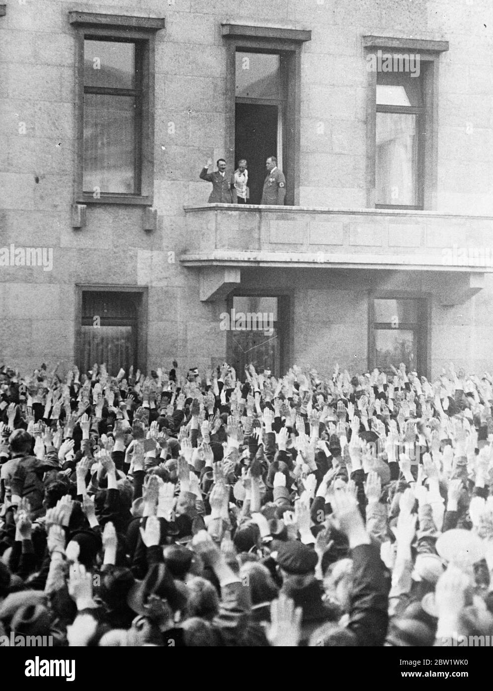 Hitler kehrt zusammen mit einem Geburtstagsgruß zurück. Bundeskanzler Hitler blickte auf Tausende von hochgelobten Armen herab, als er vom Balkon der Kanzlerei in Berlin den Gruß einer riesigen Menge von Bewunderern an seinem 48. Geburtstag angab. Foto zeigt, dass Bundeskanzler Hitler den Gruß seiner Gratulanten von einem Balkon des Kanzleramtes zurückbringt. 21. April 1937 Stockfoto