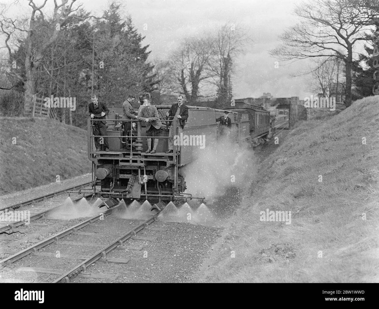 Great Western Railway startet Unkrautvernichtung Kampagne "Schnappen Sie sie mit "Spress" Express. Der "Spry" Express, und Sie trainieren, der den Tod in 20 Meilen pro Stunde auf Unkraut verwirkt, das auf den Great Western Railways Lines wächst, hat im Oswestry District von Shropshire seine Arbeit aufgenommen. Der Zug besteht aus einem Motor, drei Lokomotivendern, die 9 1/2 Liter Wasser halten, die in riesige "Wasserdosen" mit einstellbaren Düsen umgewandelt wurden, einem Tankwagen, der 2000 Liter Chemikalien in konzentrierter Lösung hält, und Wachen Bremskraftwagen. Lösen Sie einen Teil Wasser auf einen Teil Unkrautvernichter Stockfoto