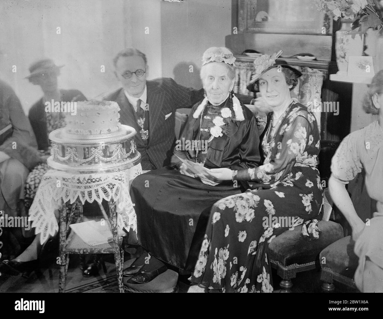 Englands älteste Frau feiert 105. Geburtstag mit Party. Herzlichen Glückwunsch. Mrs Mary Stubbin von Holford Road, Richmond, Englands älteste Frau, feierte ihren 105. Geburtstag mit einer Teeparty in ihrem Haus. Der Bürgermeister und die Bürgermeisterin von Richmond waren Gäste. Frau Stubbin, die in sechs Regierungszeiten gelebt hat, hat von König und Königin zu ihrem Geburtstag Glückwünsche erhalten. Sie ist eine Großnichte von John Constable, dem Landschaftsmaler, und selbst gebürtig aus Essex. Foto zeigt, Frau Mary Stubbin mit dem Bürgermeister von Richmond, JW Maycock, und dann Mayoress, auf einer Teeparty. 31 Mai 1937 Stockfoto