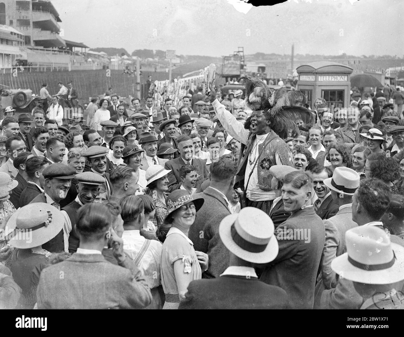 Prinz Monolulu gibt seinen Derby-Tipp an die Sonntagsmassen. Begünstigt durch echtes Sommerwetter versammelten sich große Menschenmassen, um den Derby-Kurs in Epsom heute (Derby Sonntag) zu inspizieren. Alle bunten Figuren, die Derby Day Racing das berühmteste Ereignis machen, waren auf dem Platz. Foto zeigt, Ras Prince Monolulu gibt seine Derby Reise an die große Menge auf dem Platz heute, (Derby Sonntag). 30 Mai 1937 Stockfoto