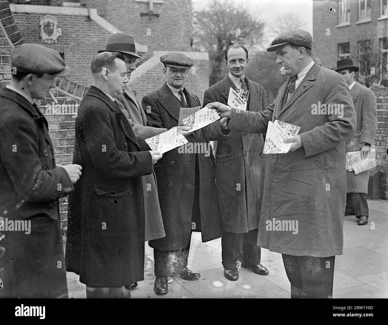 Busmen treffen sich in London, um Streikmaßnahmen zu unterstützen. In der Woodbury Hall, Green Lanes, Stoke Newington, fand eine Versammlung von Busdelegierten der Transport and General Workers Union statt, bei der erwartet wurde, dass die endgültige Zustimmung zu den Streikmaßnahmen nach dem vollständigen Scheitern der Verhandlungen, die die ganze Woche über geführt wurden, gegeben wird. Das Foto zeigt, wie die Busleute Flugblätter verteilten, die den Standpunkt der Busmänner während der Sitzung vorbringen. 30. April 1937 Stockfoto