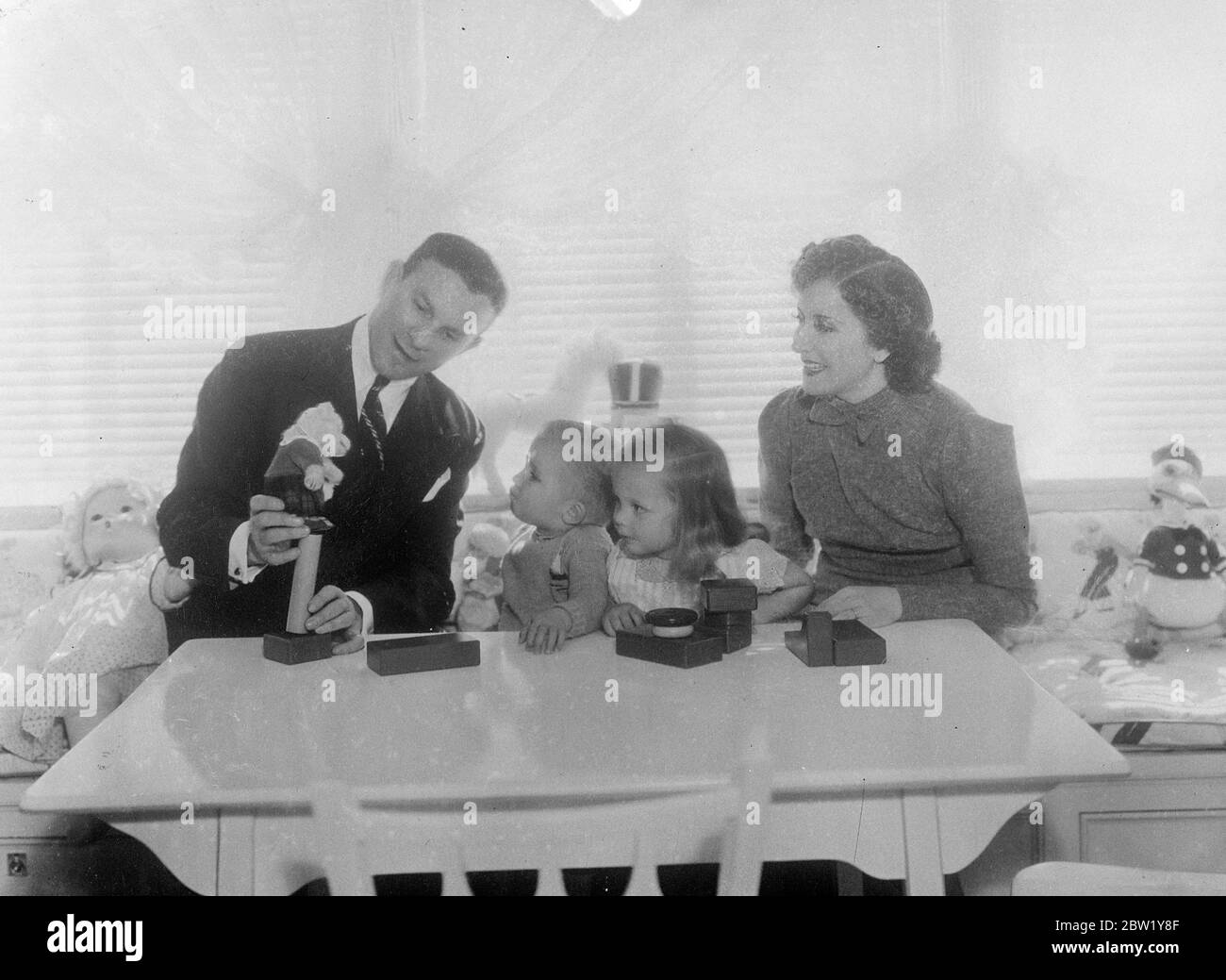 Screen Exzentrik und ihre Adoptivkinder. Fotoausstellungen: George Burns und Gracie Allen, das berühmte exzentrische Team der Filme, nehmen sich einen Urlaub von ihrer üblichen Aufgabe, Tausende zu unterhalten, um die beiden Kinder, die sie adoptiert haben - Sandra und Ronnie - in ihrem Hollywood-Haus zu unterhalten. Juni 1937 Stockfoto