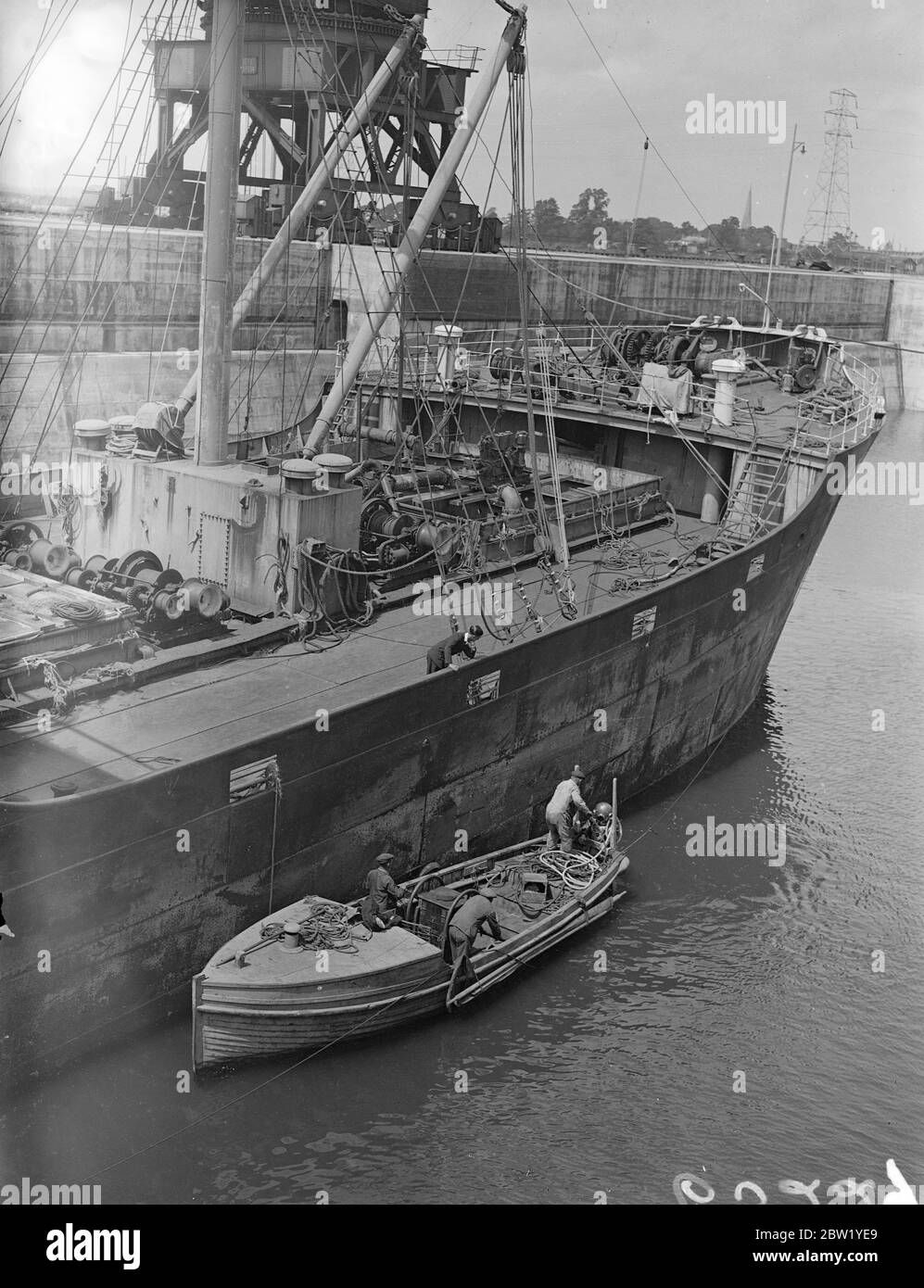 Der Taucher inspiziert die Bergung des Dampfes, nachdem er als Totalverlust aufgegeben wurde. Als Totalverlust aufgegeben, nachdem sie in Nebel auf St Catharine's Point, Isle of Wight, aufgeflagt war, hat der italienische Dampfer Luigi Accame von einer Firma gerettet, die an dem No-Ergebnis, No Pay-System arbeitet. Der Dampfer ist in King George V Dock in Southampton und ein Taucher ist die Überprüfung der Schäden an Rumpf. Foto zeigt: Der Taucher geht hinunter, um den beschädigten Rumpf der Luigi Accame im Dock in Southampton zu inspizieren. Juni 1937 Stockfoto