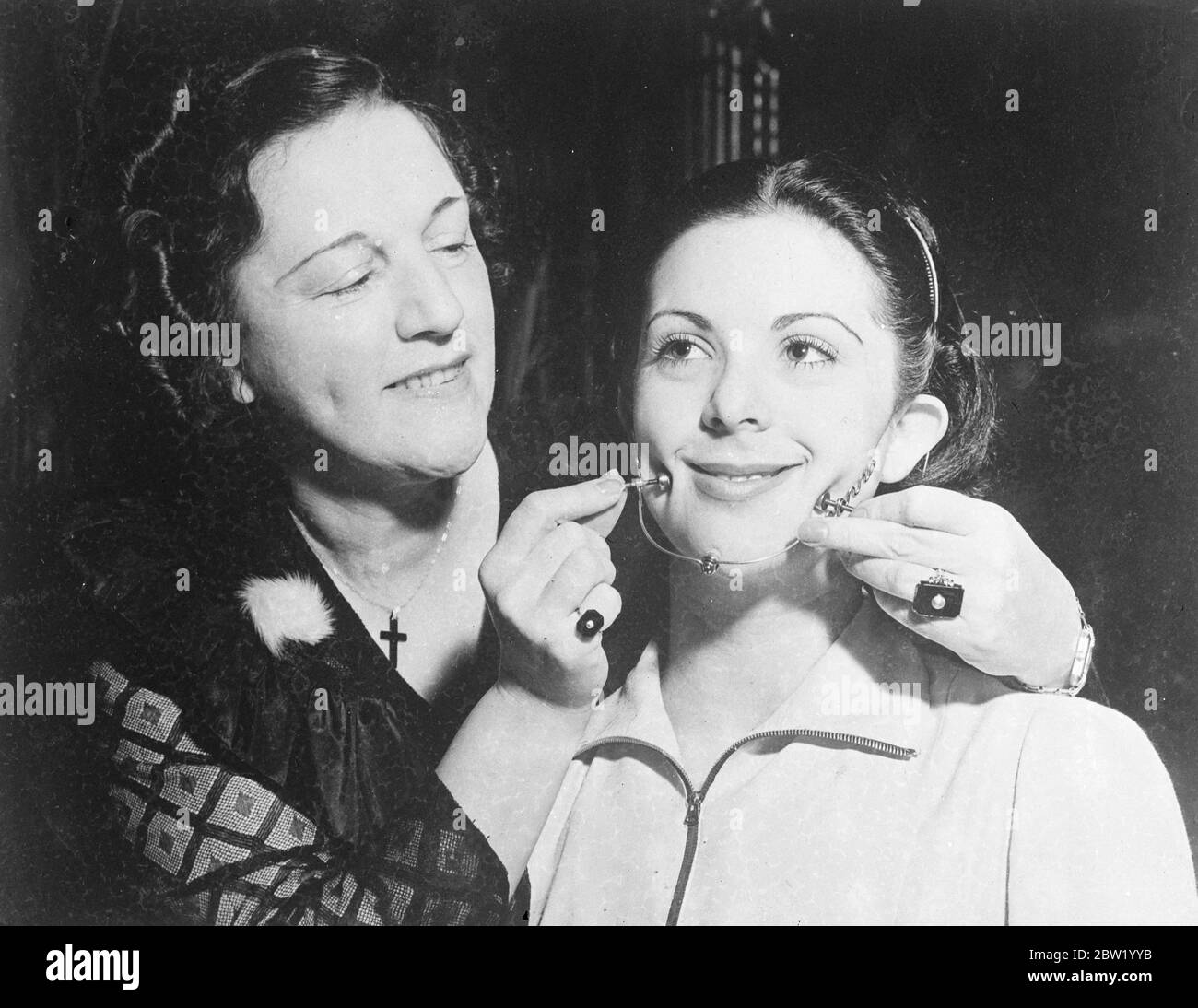 Ein neues Schönheitsgerät, das Grübchen nach Bestellung produziert, wurde auf dem jährlichen National Inventors Congress im Hotel Edison, New York City, gezeigt. Frau Isabella Gilbert demonstriert ihre Isabella Dimpler. 18 Juni 1937 Stockfoto