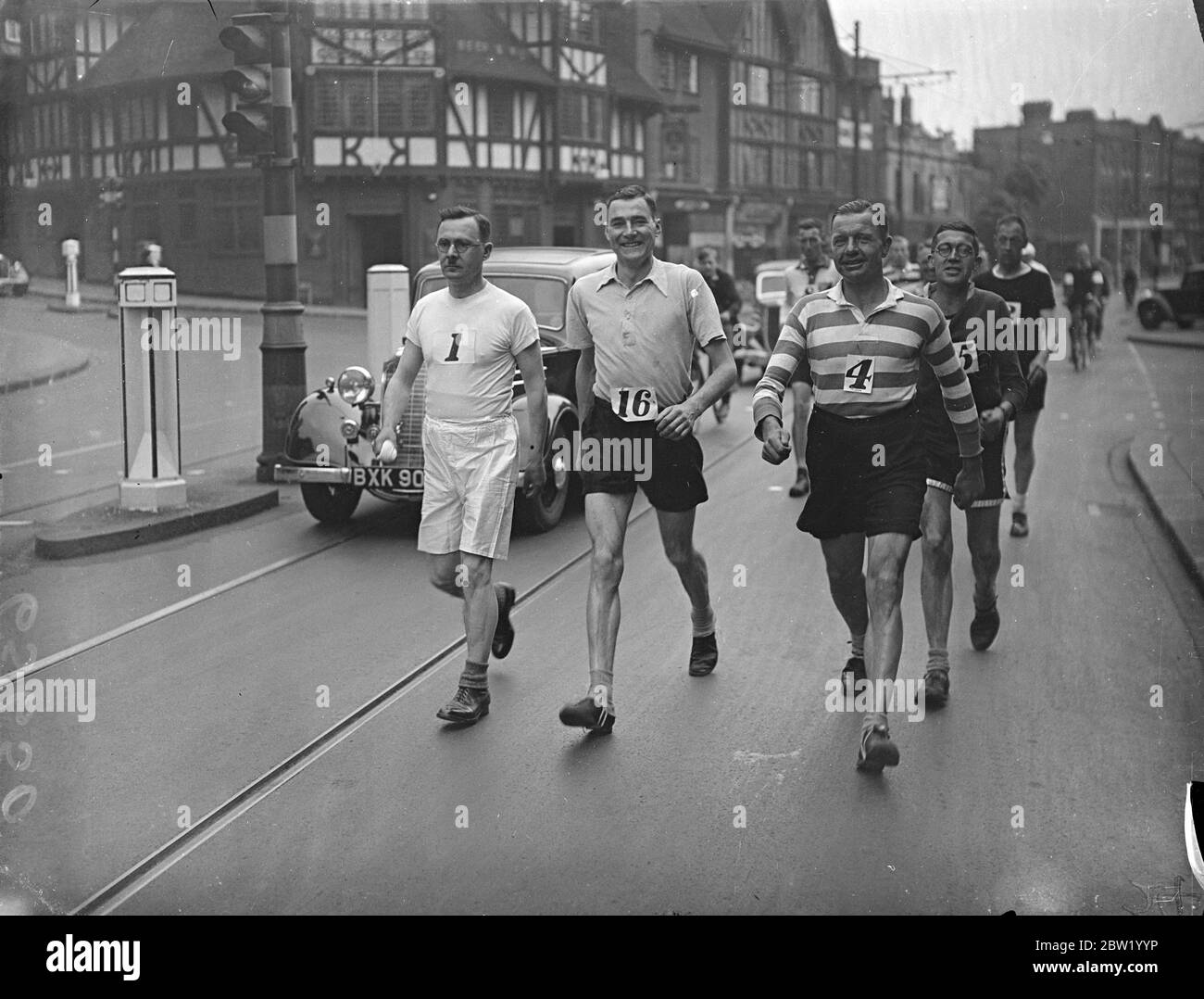 18 Teilnehmer starteten vom Blue Anchor in South Croydon auf ihrem 104 Meilen langen Spaziergang von London nach Brighton und zurück. T. W. Richardson (16) - Weltrekordhalter für 100 Meilen; H. C. Ashenden (1) S. Clark (4) und William Cockle (5) zu Beginn des Rennens. 18 Juni 1937 Stockfoto