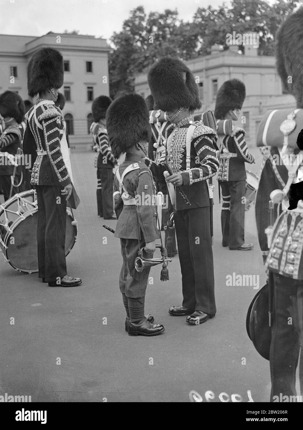 Eine Inspektion der ersten Bataillon-Grenadier-Garde wurde in Wellington Barracks durch Generalmajor B. N. Sergeon-Brooke, General Officer Commanding, London District, durchgeführt. Ein 15-jähriger Bugler der Band, der für die Inspektion gespuckt und gespuckt wird. 29 Juni 1937 Stockfoto