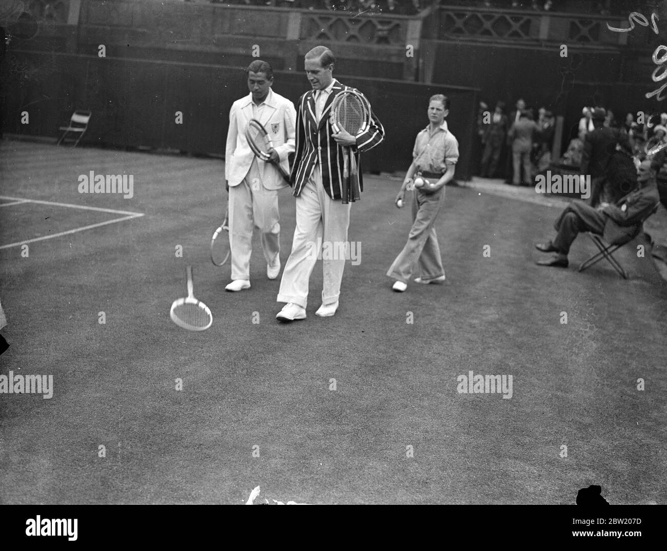 Von Cramm und Yamagishi werfen sich auf den Mittelplatz. Baron Gottfried von Cramm (Deutschland) und J Yamagishi (Japan) trafen sich in der dritten Runde der Männer-Singles am Centre Court in Wimbledon. Foto zeigt, wie Yamagishi und von Cramm sich mit einem Tennisschläger auf den Center Court werfen. 24 Juni 1937 Stockfoto