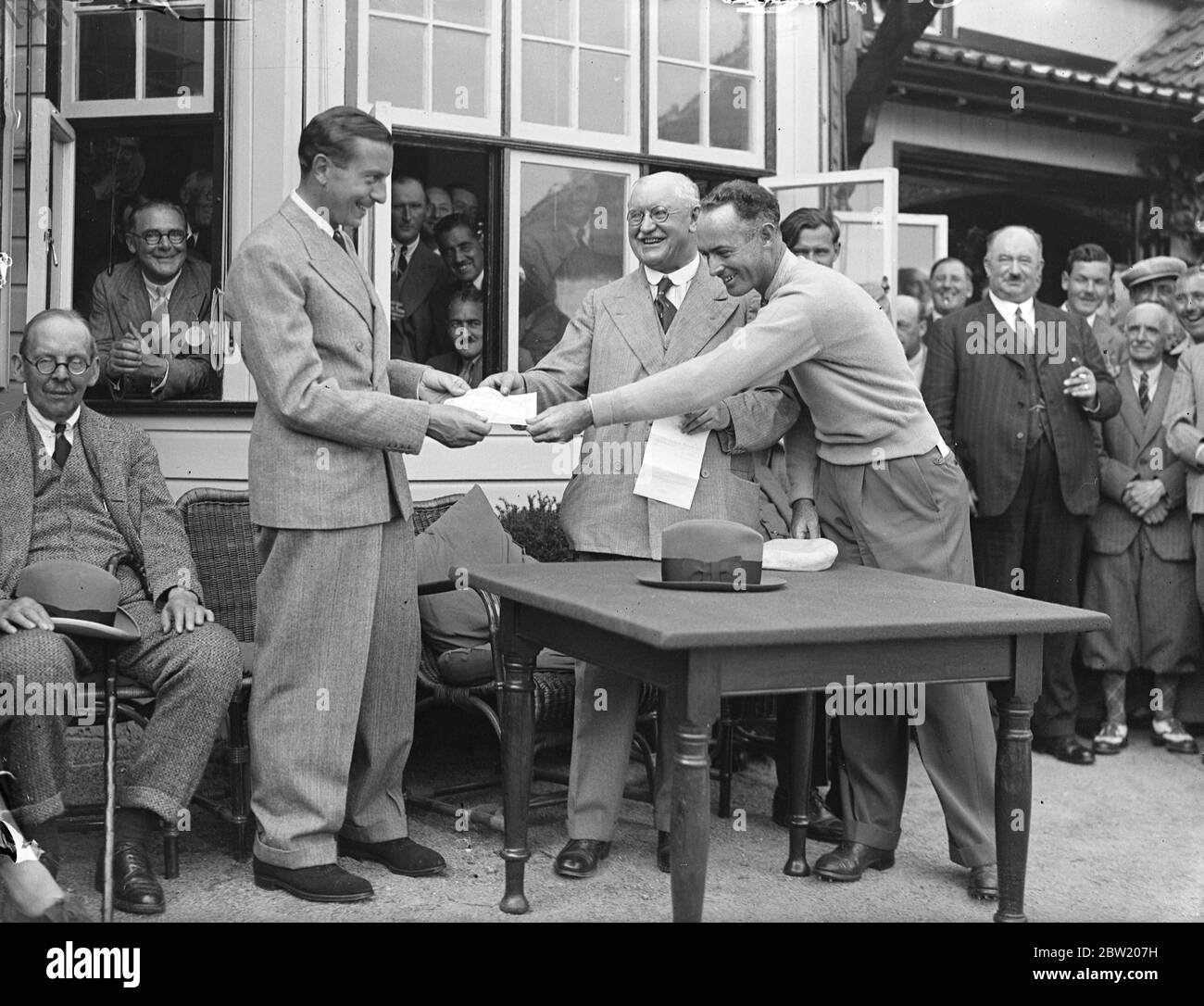 Henry Cotton erhält den Â£500 Scheck von Sir Emsley Carr. Er besiegte Densmore Shute, den amerikanischen Ryder Cup-Spieler und gewann das Spiel am 13. Loch am 13. Tag des Monats beim britischen Open Golf Champion in Walton Heath. 13 Juli 1937 Stockfoto