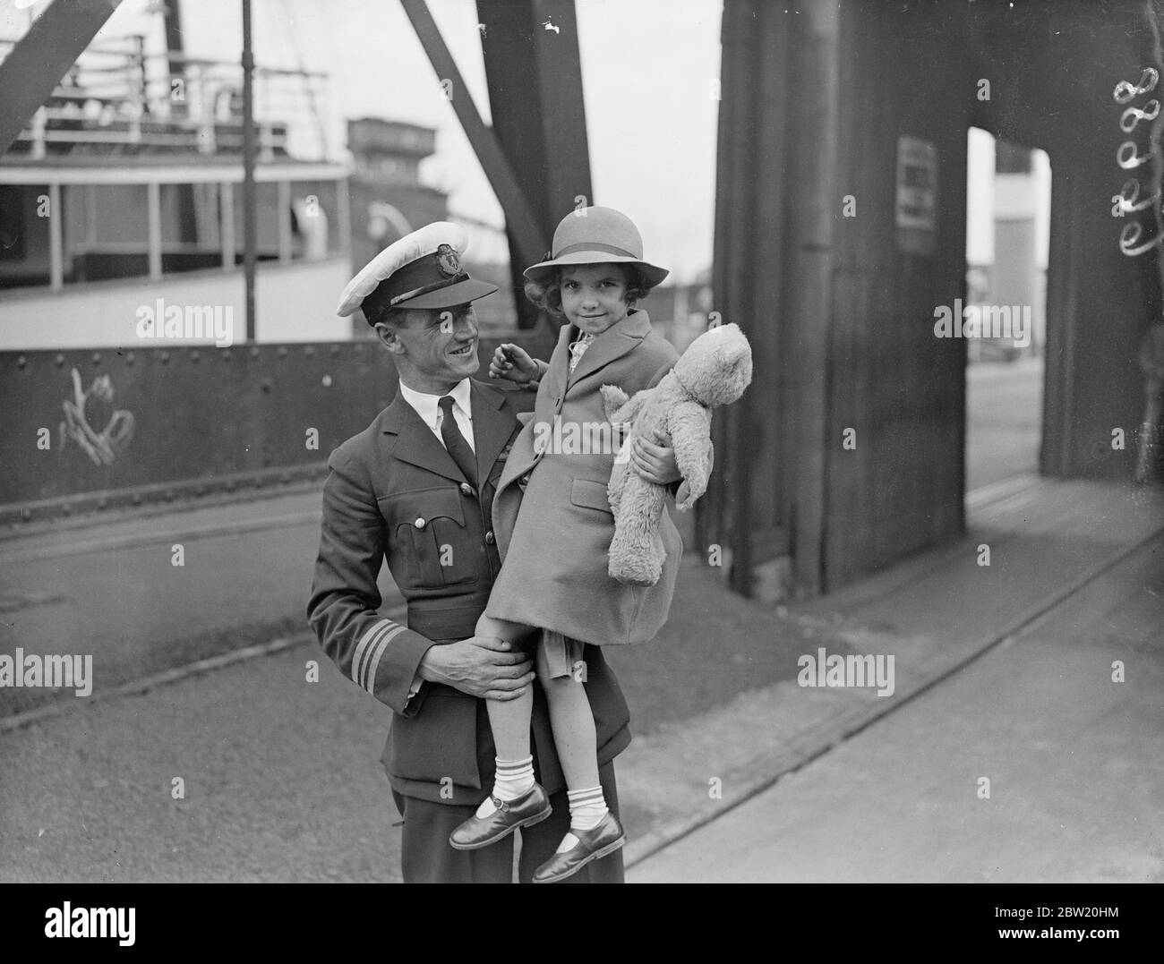 Der fünfjährige Pat Whitehouse kommt nach seiner Reise aus Uganda mit dem Empire-Flugboot Courtier in Southampton an. Pat und ihr Teddybär Kapitän J. C Harrington von The Courtier. 20 Juli 1937 Stockfoto