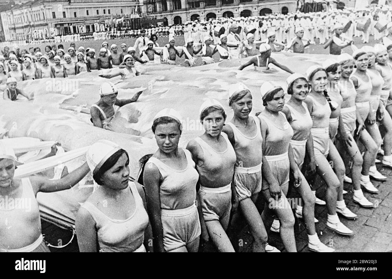 Schulkinder schwimmen in einer klugen Darstellung eines Schwimmbades, das über den Roten Platz getragen wurde, wo sie 40,000 Athleten aus den 11 Republiken, die die Sowjetunion bilden, zusammenschlossen, marschierten triumphierend über den Roten Platz Moskau, Den 20. Jahrestag der Revolution und deren Inbetriebnahme der neuen Stalin-Verfassung zu feiern. In der Parade waren Vertreter aller Arten von Sport von d Gymnastik zu Jäger mit Adler. 15 Juli 1937[?] Stockfoto