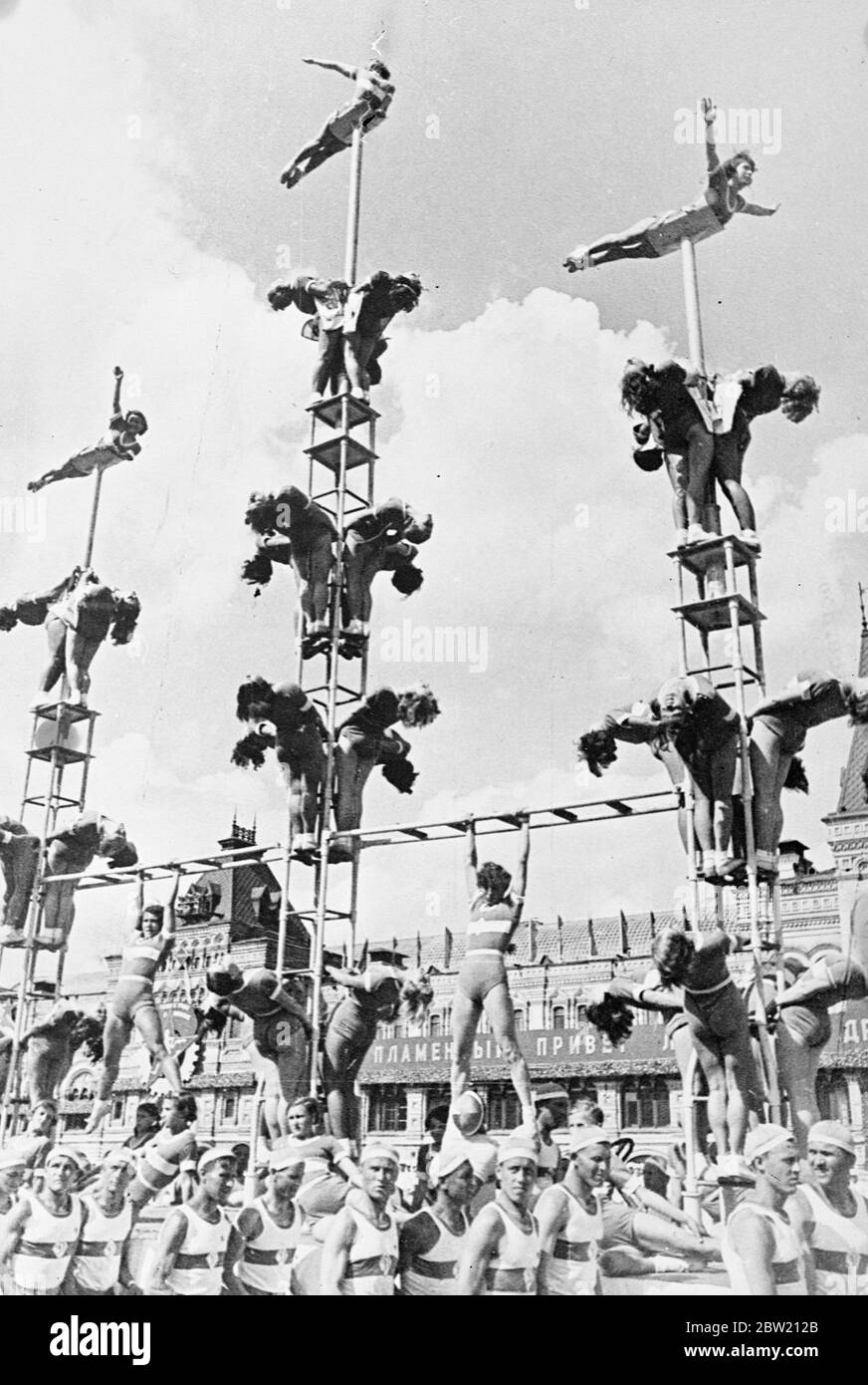 Mädchen Mitglieder ihrer Dynamo Sport Society of Moscow Form Pyramiden, wie sie über den Roten Platz von männlichen Athleten getragen werden. Wo sie 40,000 Athleten aus den 11 Republiken, die die Sowjetunion bilden, trat triumphierend über den Roten Platz Moskau, Den 20. Jahrestag der Revolution und deren Inbetriebnahme der neuen Stalin-Verfassung zu feiern. In der Parade waren Vertreter aller Arten von Sport von d Gymnastik zu Jäger mit Adler. 15 Juli 1937 Stockfoto