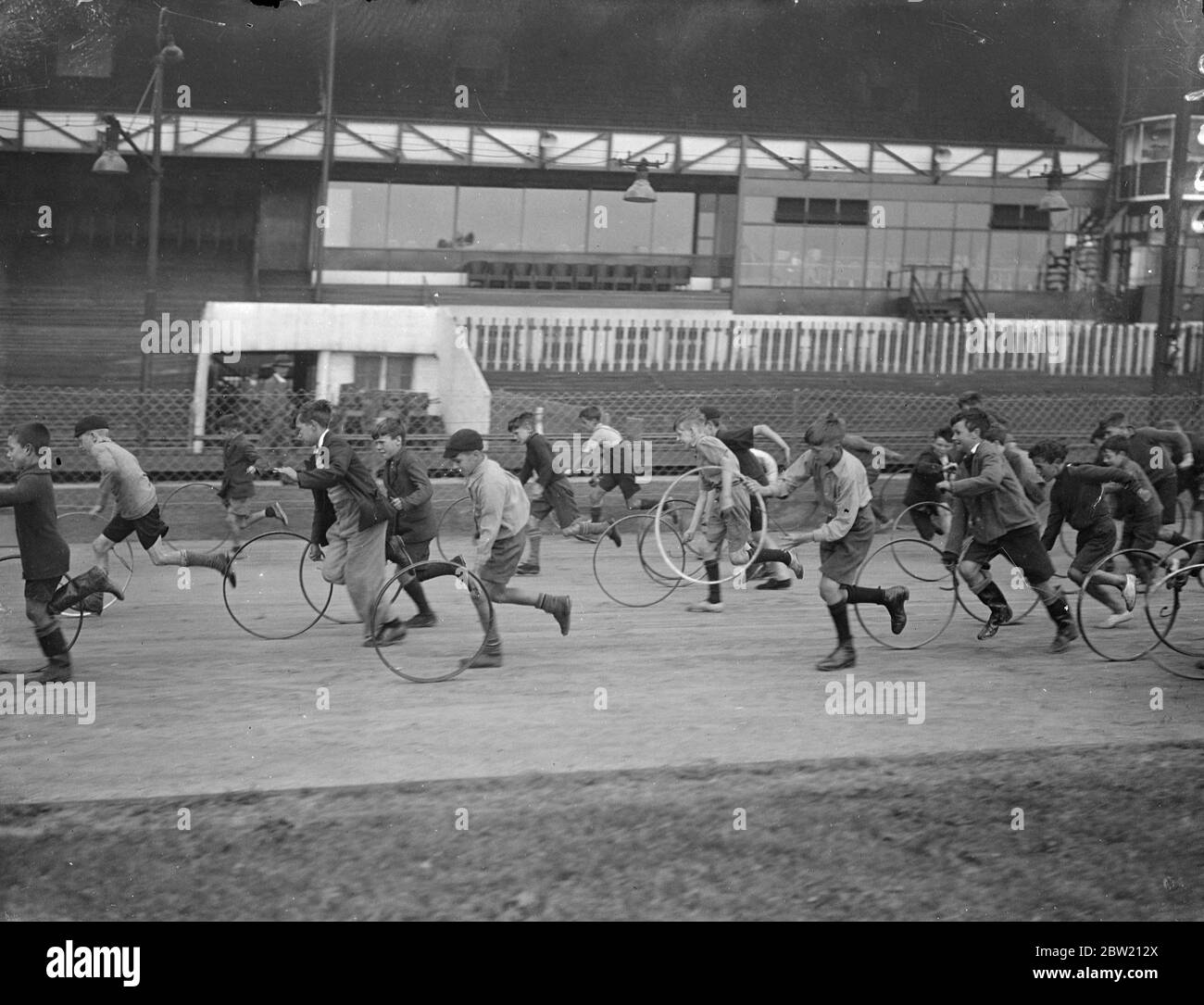Reifen wirbeln um West Ham Stadium von ihren Besitzern verfolgt. Tausende von armen Kindern, würden Geschwindigkeit Dämonen, eingedrungen West Ham Stadium, Heimat von Windhund und Speedway Rennen für das jährliche Rennen dort nächste Woche stattfinden zu üben. 10 Juli 1937 Stockfoto