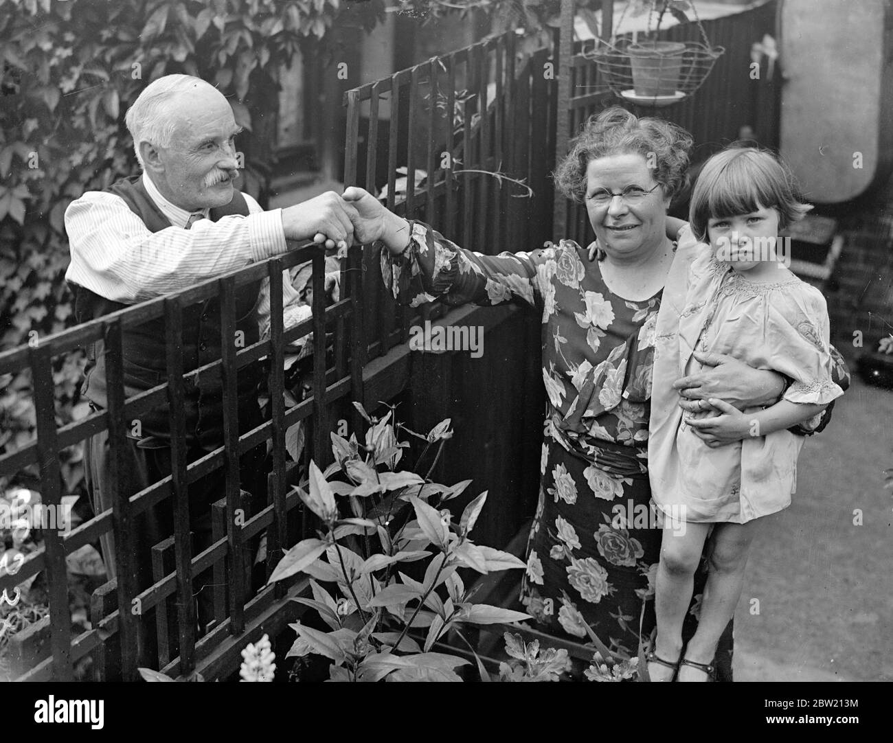 Frau Annie Taylor, die designierte Bürgermeisterin von East Ham, im Alter von 52 Jahren, hält ihre dreijährige Enkeltochter Thelma Taylor und erhält Glückwünsche von einer Nachbarin. Sie verließ die Schule, als sie 13 war, um Hausangestellte zu werden und wird nun die erste Bürgermeisterin des Bezirks sein. Sie hat sich selbst ausgebildet, sagt sie über das Muster der wohlhabenden Menschen, in deren Häusern sie arbeitete. 15 Juli 1937. Stockfoto
