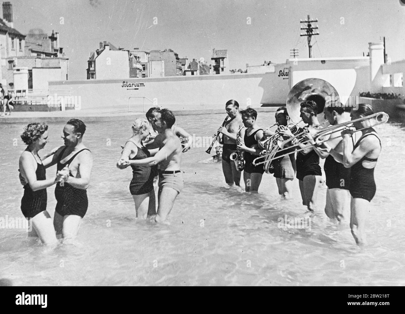 Brüssel ist jetzt in einer Hitzewelle schwelend, Badegäste können Fuchstrotten und andere Tänze im Wasser zur Musik einer Band in Badekostümen aufführen. Bis 18. August 1937. Stockfoto