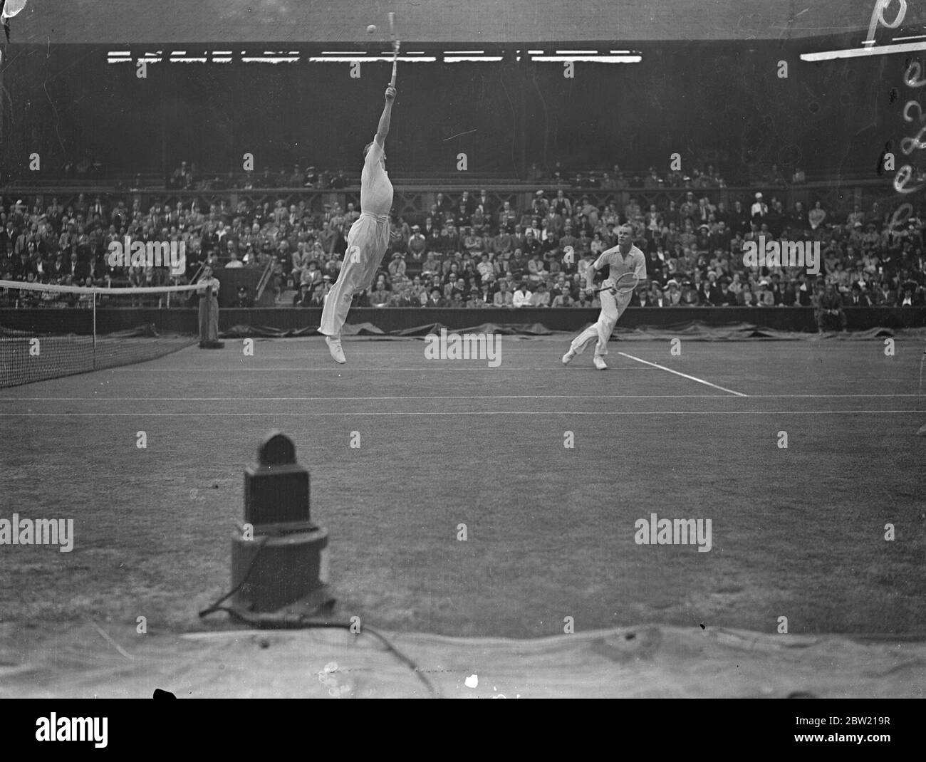 Donald Budge springt beim Spiel gegen Gene und Mako, die Amerikaner, die Wimbledon Doppel-Champions sind, um den Ball zu spielen, nahm die ersten beiden Sätze 6:3; 7-5 von CRD Tuckey und SH Wilde im Doppel der Davis Cup Challenge Runde in Wimbledon. 26 Juli 1937 Stockfoto