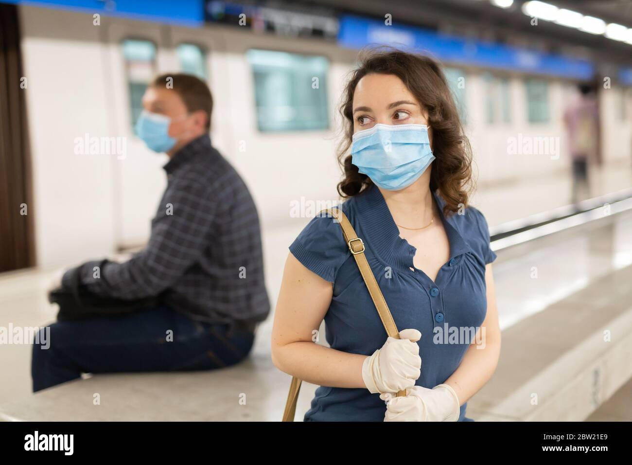 Attraktive Frau trägt medizinische Maske und Gummihandschuhe warten auf Zug  in Plattform der U-Bahn-Station. Neue Lebenswirklichkeit während COVID 19  pandemi Stockfotografie - Alamy