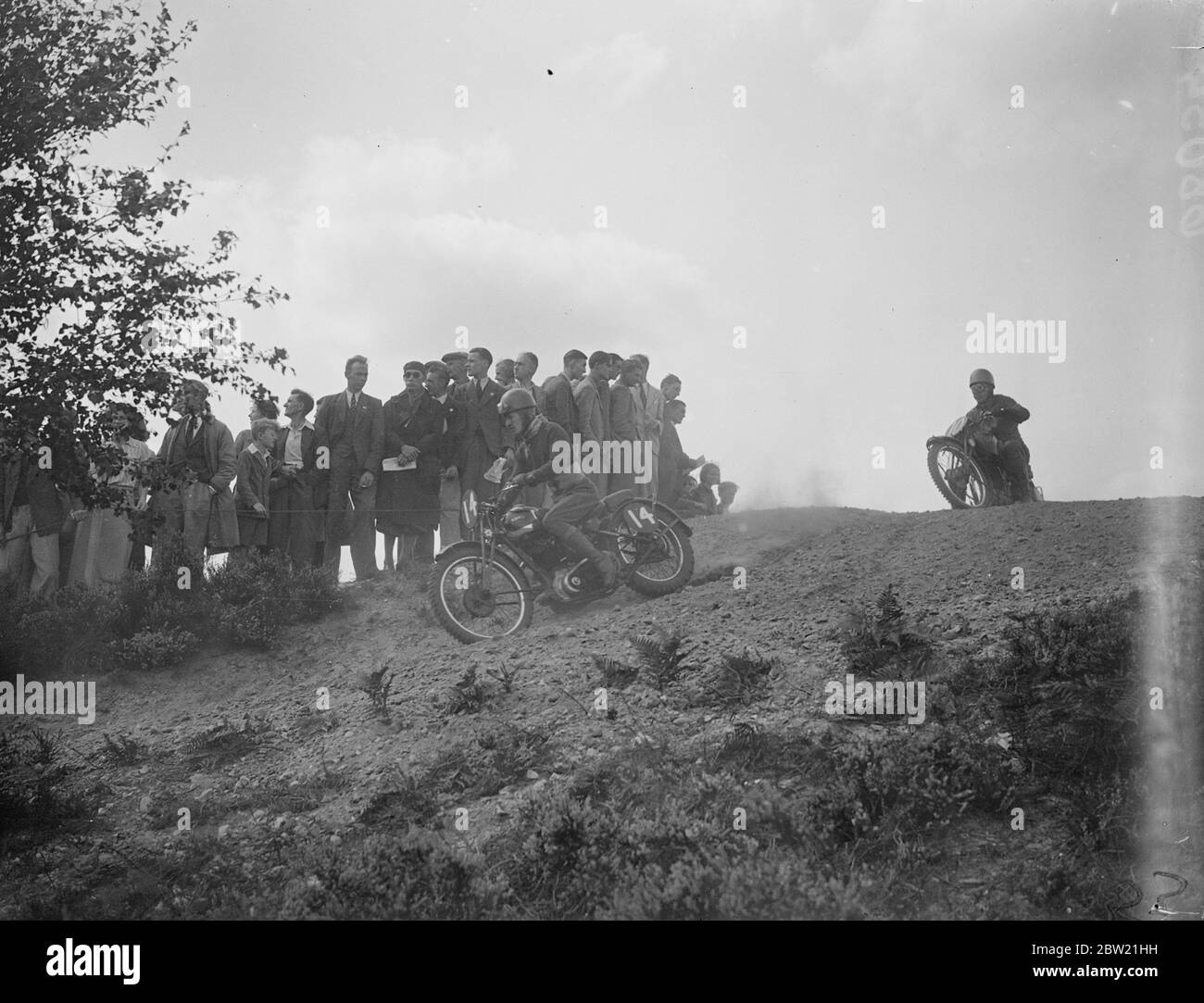 M. Banks (ariel) führt T.Andrews (Velocette) um eine der Kurven auf einem steilen Hügel. Motorradfahrer mit einem Vorgeschmack auf richtig raue Fahrt nahmen am Scramble des Amateur Motor-Cycle Clubs in Bagshot Heath, Surrey, Teil. September 1937. Stockfoto