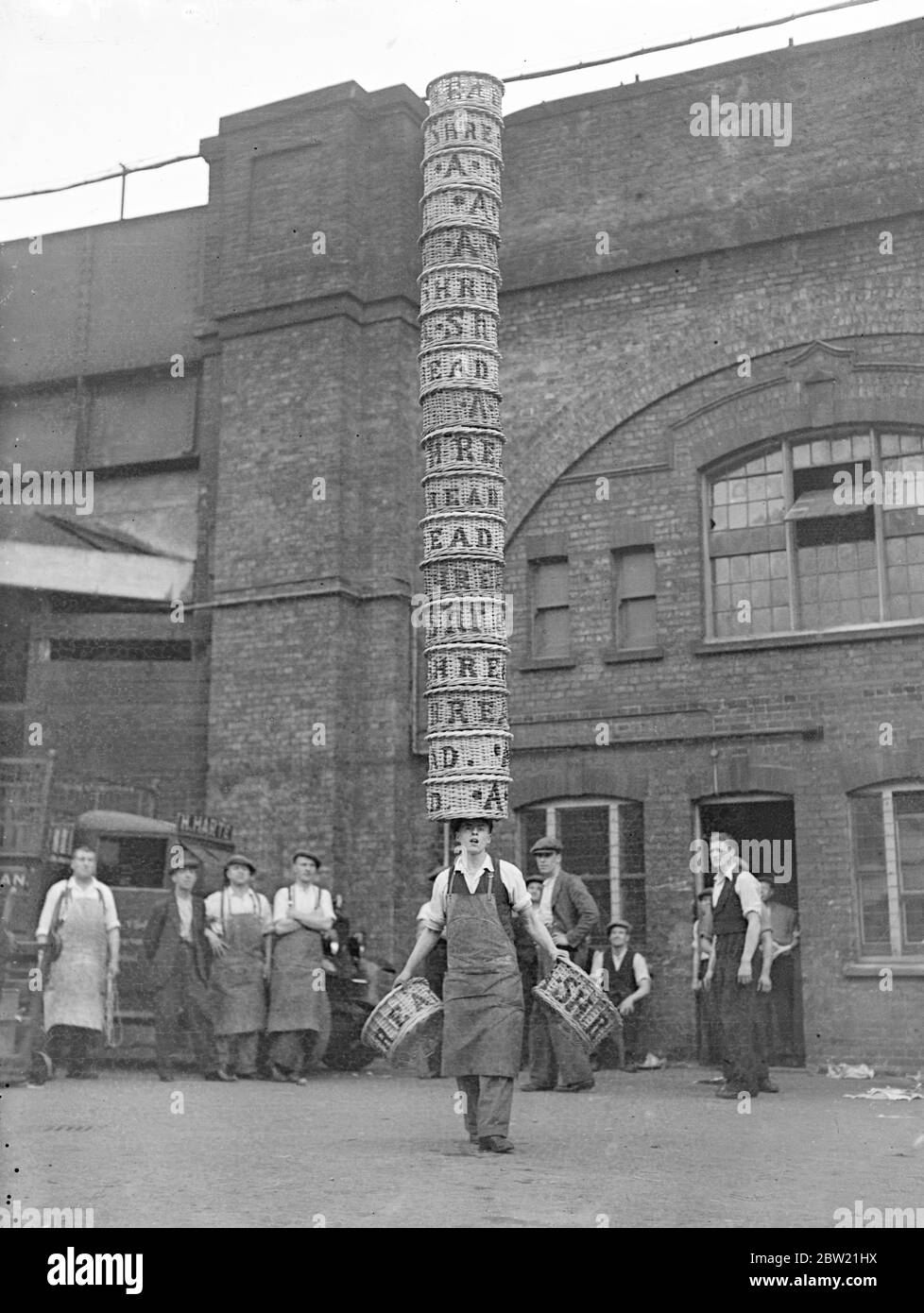 ALF Hardy, 17 Jahre, trägt 18 Körbe auf dem Kopf und einen in jeder Hand auf dem Borough Market. ALF, ein Junior-Portier auf dem Markt, ist auf den ersten Preis von Â£20, der von Charlie Chaplin an den Gewinner der All-England Half-Bushel Basket Championship der Borough Market Athletic Association Sport in Herne Hill am 9. September überreicht wird, zu gewinnen. Dies ist das siebte Jahr in Folge, in dem Charlie Chaplin den ersten Preis verliehen hat. Bis 31. August 1937 Stockfoto