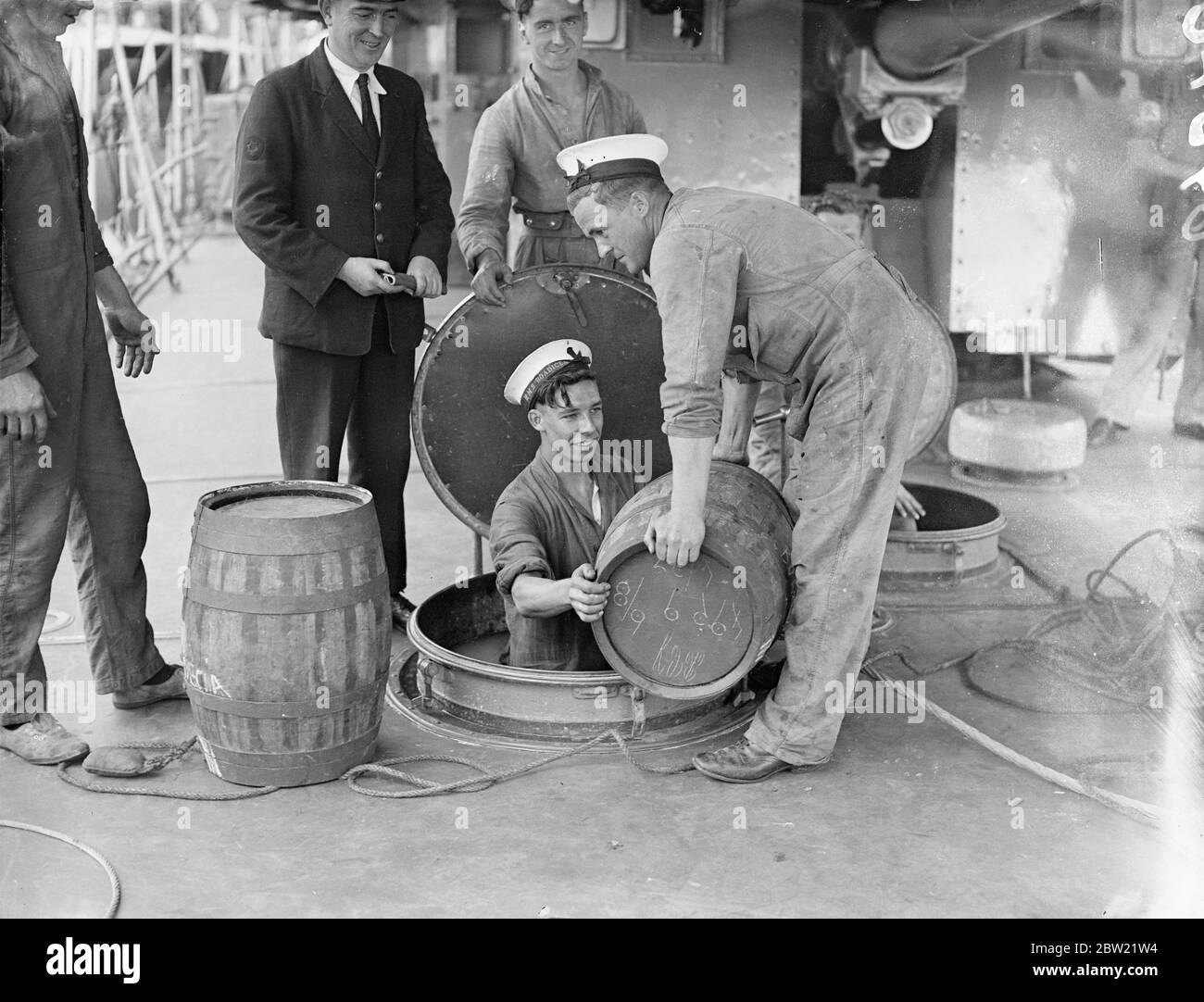 Bewertungen der H.M.S Boadicea über das Mittelmeer, um Piraterie Patrouille durch die Nyon-Vereinbarung autorisiert helfen, laden Fässer mit Rum in den Frachtraum des Zerstörers, bevor sie Portsmouth verlässt. 16. September 1937. Stockfoto