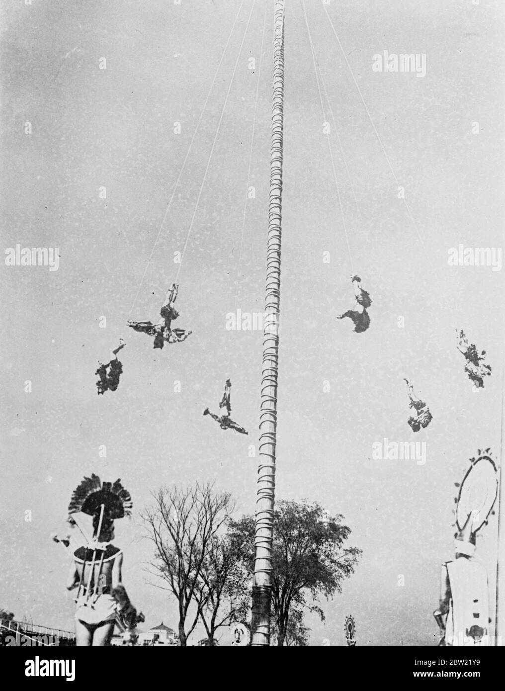 Der Höhepunkt des spektakulären Flying Pole Dance der Otomien Indianer aus Mexiko. In einer spektakulären Ausstellung im Charter Jubilee Festival in Chicago, die von einer Reihe von Indianern aus Pahuatlin, Mexiko, gegeben wurde. Sechs Indianer, die mythische Figuren darstellen, klettern auf die Spitze des 50 Fuß hohen Pfeils und tanzen auf einer kleinen Drehplattform. September 1937. Stockfoto