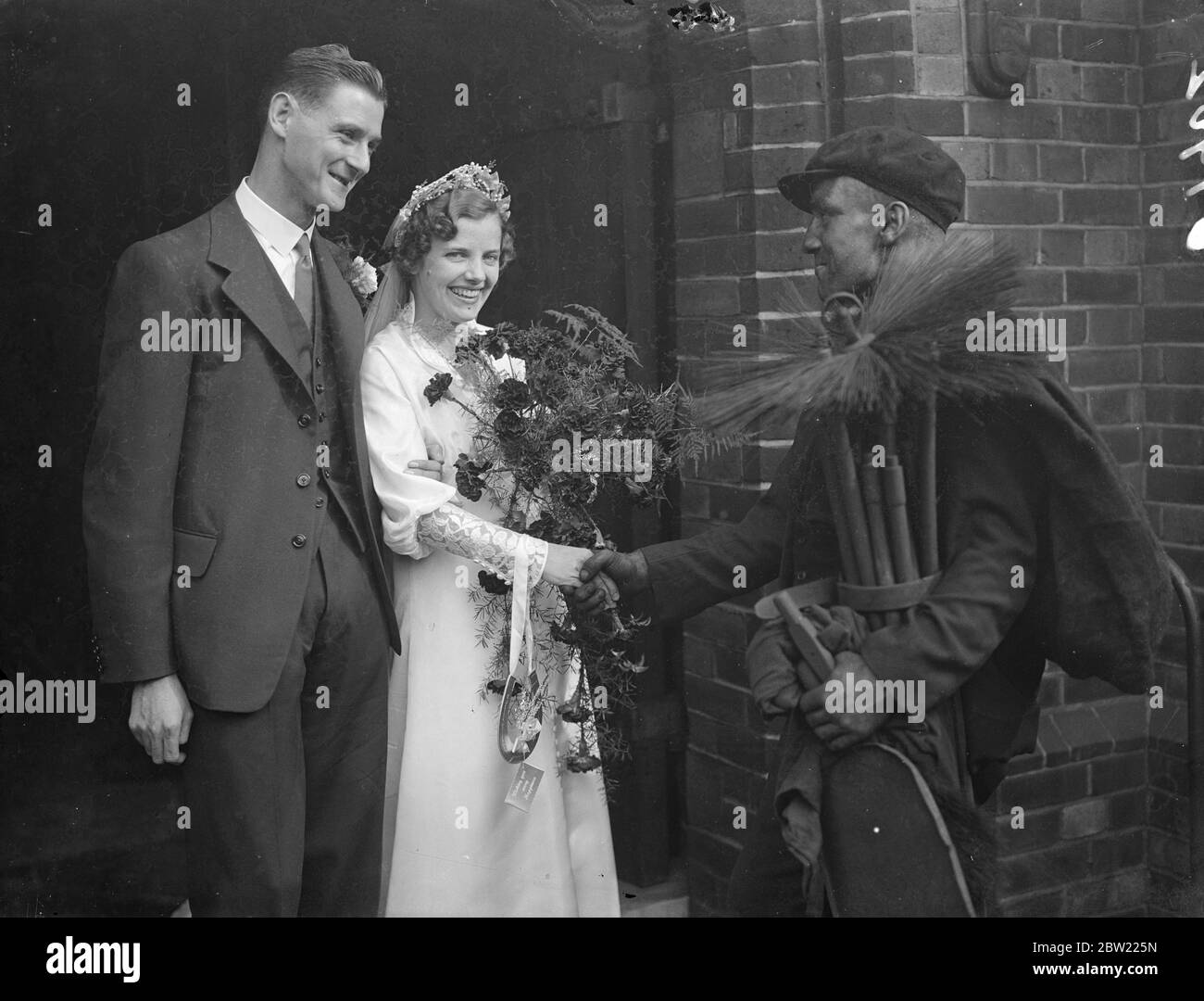 Der örtliche Sweep, Herr Breezer, nahm an der Hochzeit Teil und wünschte dem Brautpaar viel Glück, als Frau Ivy Worden und Herr Leslie Wall Free in der St. Thomas's Church, St. Thomas Road Highbury, geheiratet wurden. Oktober 1937. Stockfoto