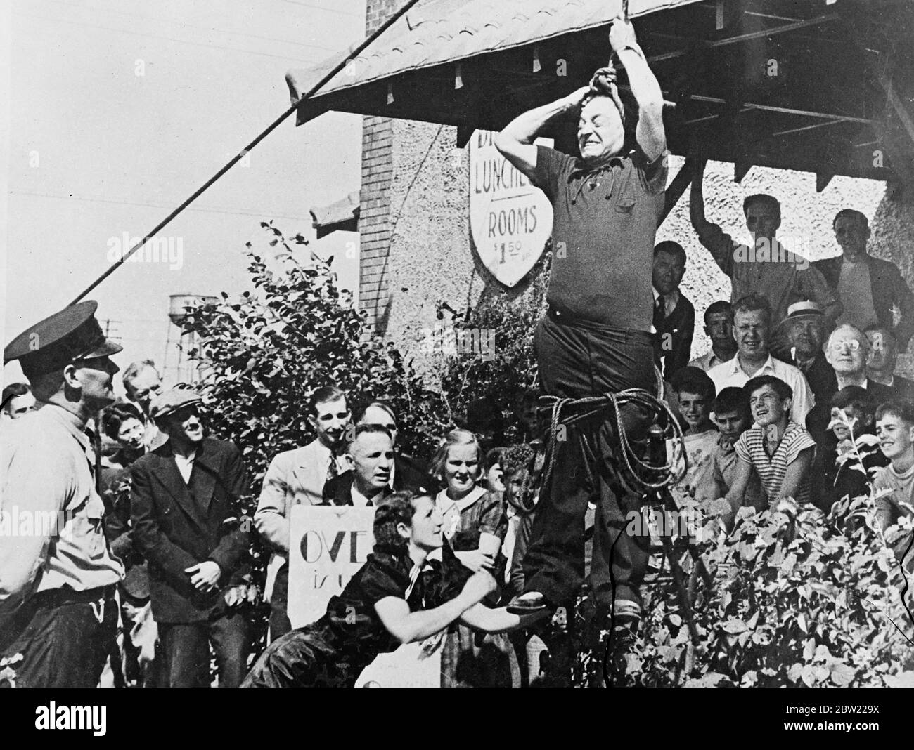 Ovette feeing seinen Hals von der Schlinge nach dem Lösen der Bindungen, die ihn an den Stuhl gebunden. Joseph Ovette aus ottawa ließ sich von einer Menge in Fort Erie, Kanada, lynchen, aber nur um eine seiner neuesten Stunts zu demonstrieren, denn er ist ein professioneller Zauberer. 17. September 1937.[?] Stockfoto