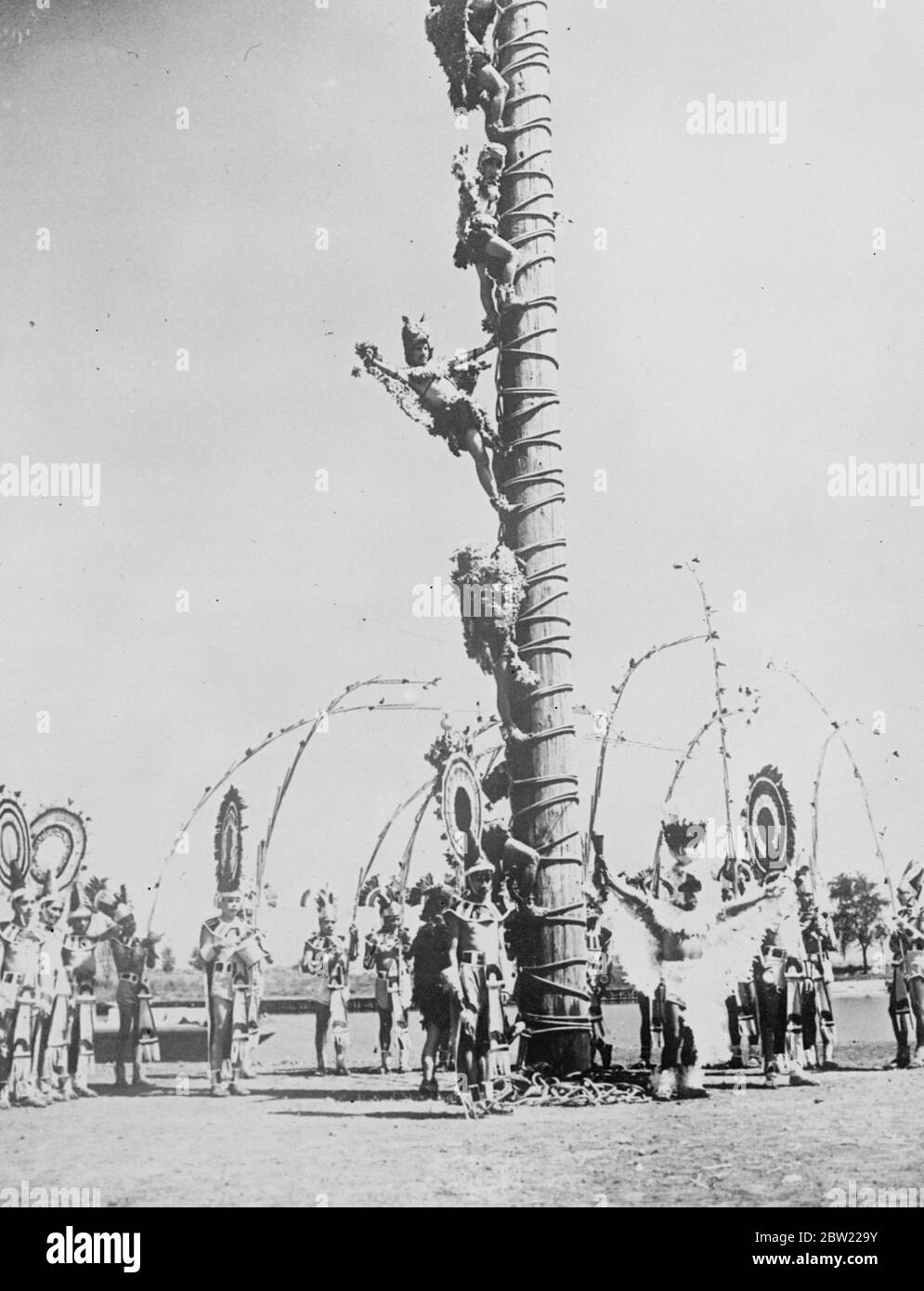 [Original Caption] die seltsam gegarten Indianer klettern die Umfrage für den Tanz. In einer spektakulären Ausstellung im Charter Jubilee Festival in Chicago, die von einer Reihe von Indianern aus Pahuatlin, Mexiko, gegeben wurde. Sechs Indianer, die mythische Figuren darstellen, klettern auf die Spitze des 50 Fuß hohen Pfeils und tanzen auf einer kleinen Drehplattform. September 1937. Stockfoto