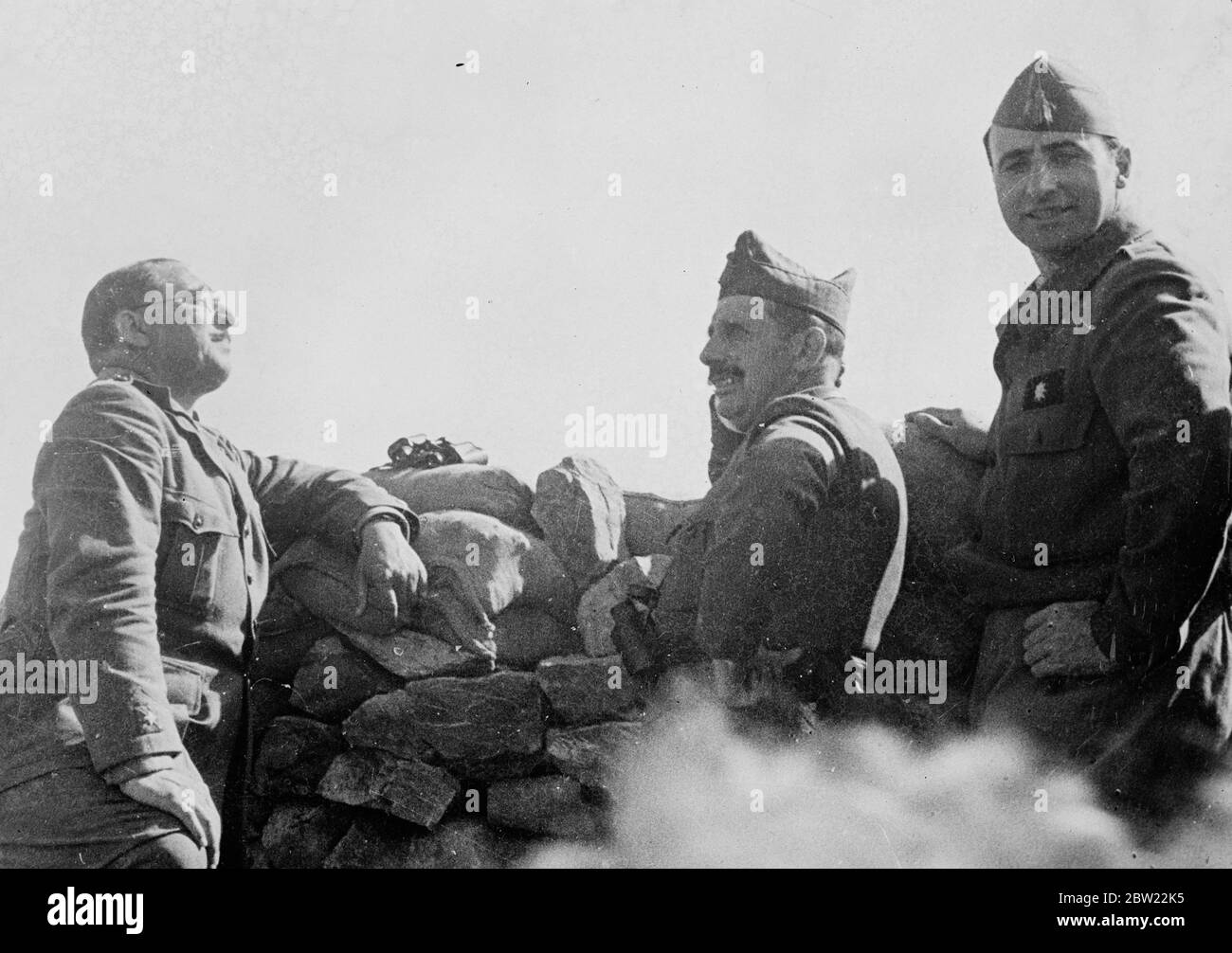 So wenig besorgt wie sie es bei einer Gartenparty für spanische nationalistische Generäle tun würden, lehnen sich auf eine Steinverteidigungsarbeit für ein angenehmes Gespräch während einer Inspektion der Front-Verteidigung an der Nordfront in Spanien. Oktober 1937. Stockfoto