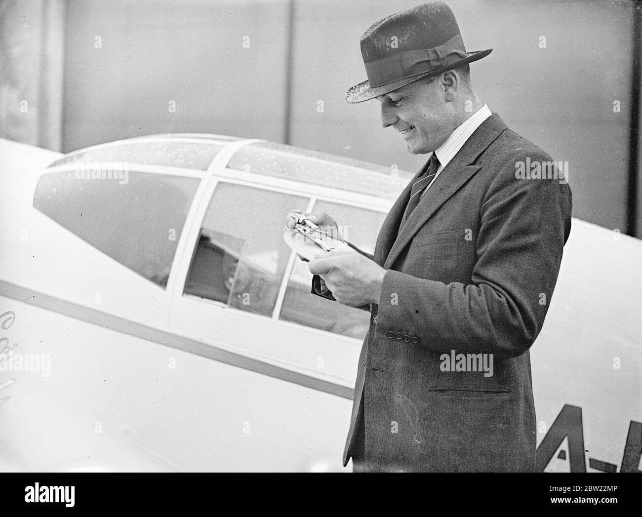 Die Piloten machten die letzten Vorbereitungen auf dem Flugplatz Hatfield, um den Start des Kings Cup-Flugrennens zu starten. Kapitän E.W Percival der Flugzeugdesigner, Einstellung der Kurs und Richtungen Suche Apparat der Percival Möwe, die er im Rennen fliegt. September 1937 Stockfoto