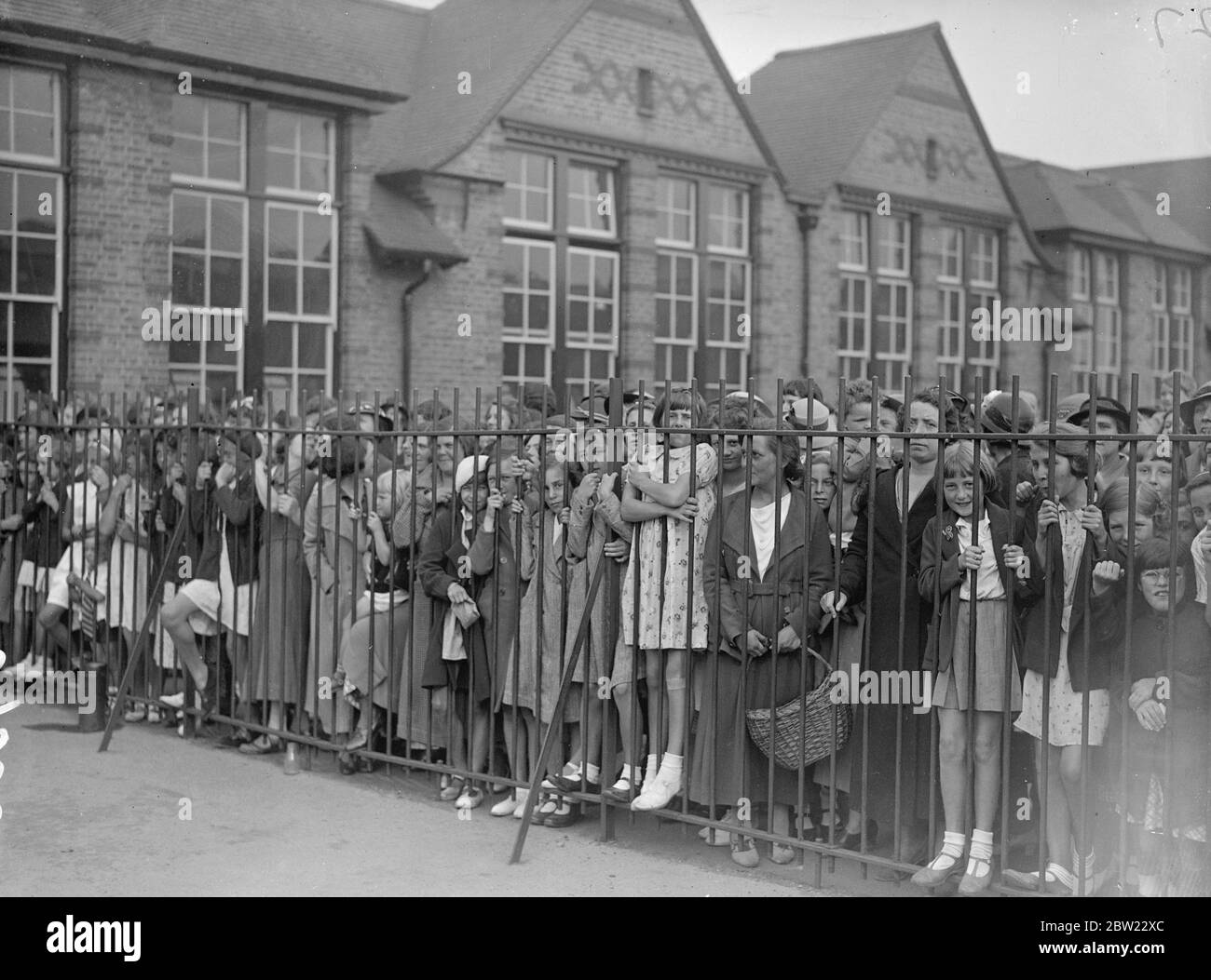 Hunderte von Schulkindern streiken in Romford, Essex, als Protest von 350 Eltern gegen die Erziehungsbehörden des Essex County, die forderten, dass die Kinder in eine neue Schule in der Whale-Bone Lane, Chadwell Heath, gehen sollten. Kinder hinter dem Geländer auf dem Spielplatz der alten Schule in der London Road. Bis 30. August 1937 Stockfoto