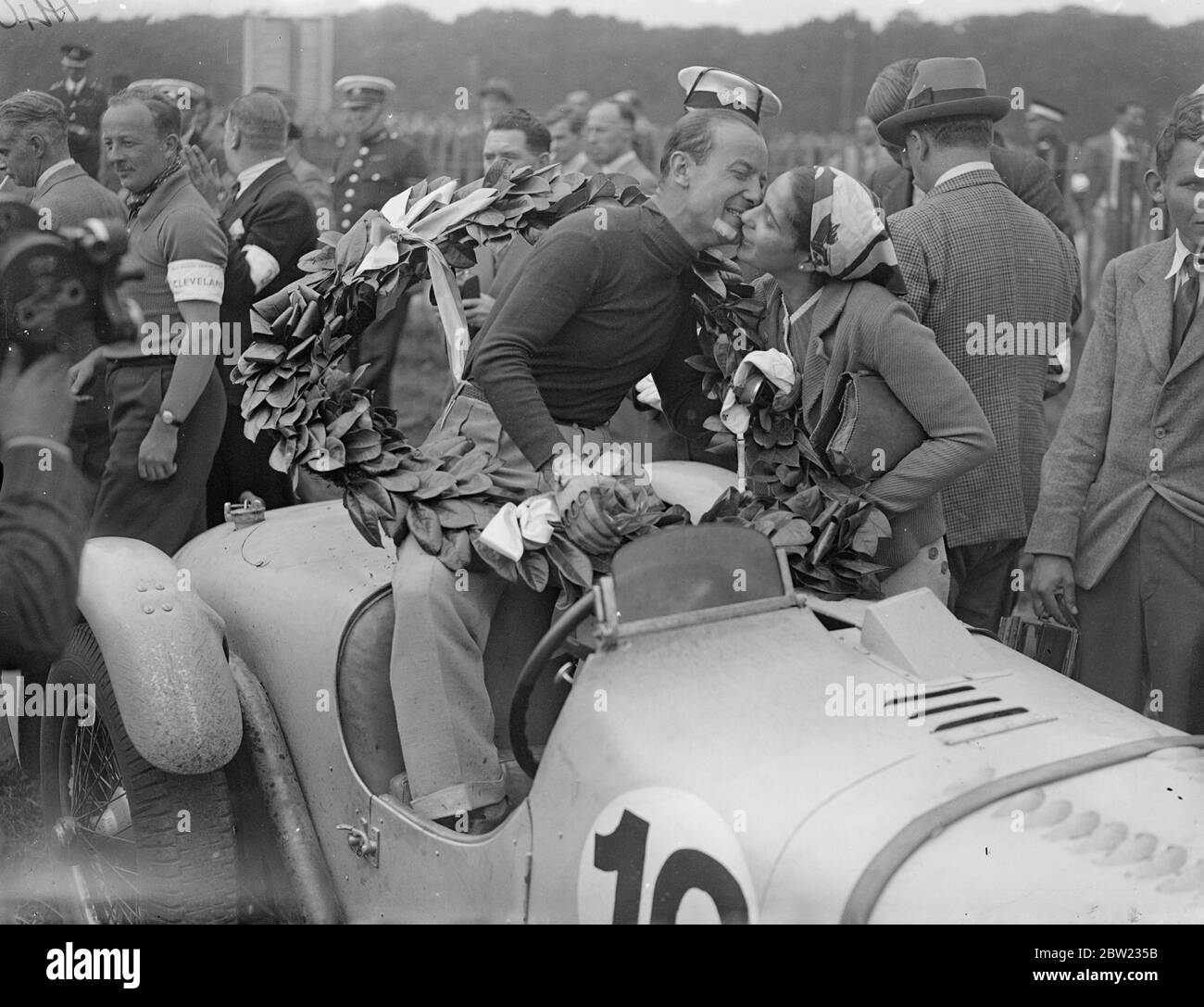 Gianfranco Cometti war mit Lorbeeren und wurde von seinem wofe geküsst, nachdem er beim internationalen Touristenrennen des Royal Automobilclubs Trophy im Donington Park in der Nähe von Derby die 312 Meilen in vier Stunden 35 Minuten 27 Sekunden bei einer Durchschnittsgeschwindigkeit von 68.7 Meilen pro Stunde zurücklegte. Das war das erste Mal, dass das Rennen in England ab 1928 1936 stattgefunden hatte. September 1937. Stockfoto