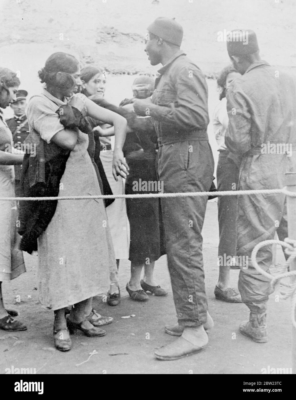 6,000 Menschen in der Massenimpfung in Casablanca. In Casablanca, Marokko, wurden massenhafte Impfungen durchgeführt, über 6,000 Menschen wurden von der Polizei aufgefahren und mussten durch Auswegsgänge zum Arzt und seinen Assistenten gehen, bevor sie freigelassen wurden. Foto zeigt, eine gebürtige Frau, die während der 'Round Up' in Casablanca geimpft wird. 12 Februar 1938 Stockfoto