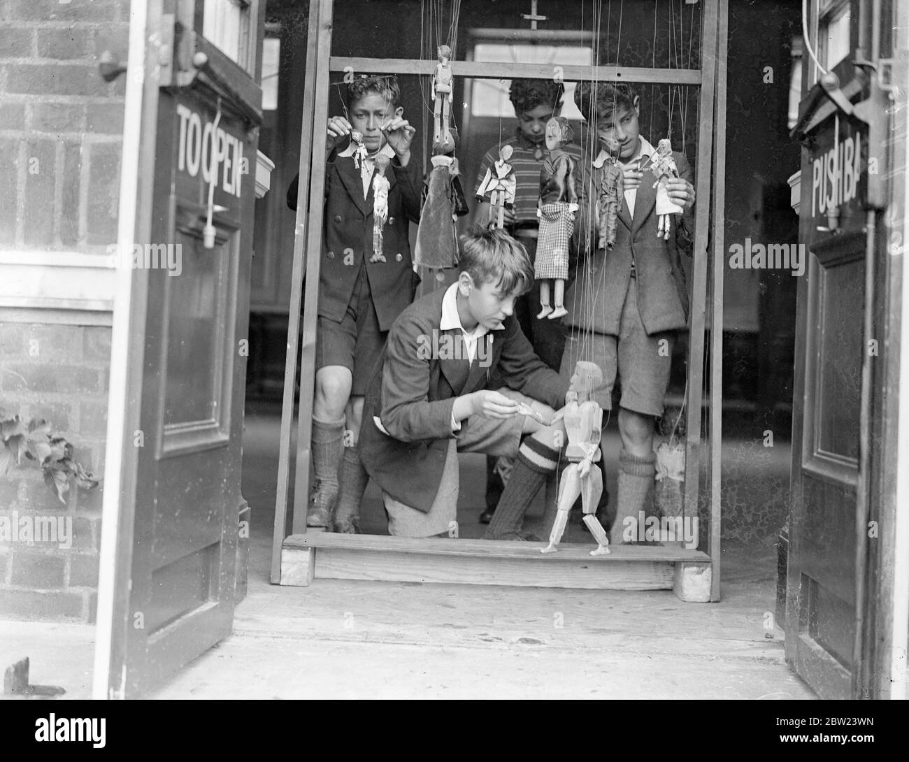 Jungs von Chingford Senior Grundschule üben mit ihren Marionetten. Die Jungen besuchen ihre After-School-Aktivitäten, wo sie ihre Marionetten in ihrem eigenen selbst gebauten Miniaturtheater zum Leben erwecken und regelmäßig in der zarten Kunst der Manipulation der Saiten geschult werden. 23 Juli 1937. Stockfoto