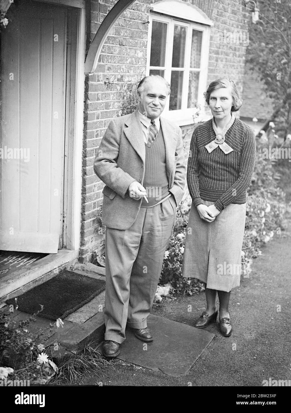 Aus dem Luxus eines palastartigen Schlosses mit 60 Zimmern im österreichischen Tirol, wurden Graf Lesven Zeppelin, 42-jähriger Neffe des deutschen Luftschiffdesigners, und seine schöne englische Frau gezwungen, das Heiligtum eines verfallenen fünfzimmerigen Häuschens im Süden Warnborough, nahe Basingstoke, Hampshire, zu suchen. Der Graf verlor sein Vermögen, nachdem Hitler Österreich annektierte. Die Gräfin, die vor neun Jahren den Grafen heiratete, kocht nun selbst. Graf Lesvan Zeppelin hat vor 14 Jahren eine Entdeckungsreise im bolivianischen Dschungel unternommen. Foto zeigt: Die Gräfin und Graf Lesven Zeppelin vor ihrem Häuschen. 16 Okt Stockfoto
