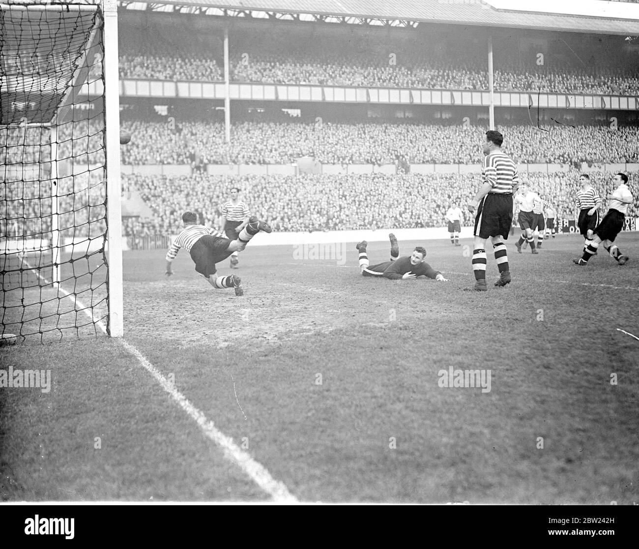 Tottenham Hotspur traf Fulham in einem Match in der zweiten Londoner Division in der White Hart Lane. Foto zeigt: Turner, der Fulham-Torhüter am Boden, schlug aber Helies, die Fulham-Mitte, stürzt sich halb ein und rettet auf der Torlinie das, was ein bestimmtes Ziel zu sein scheint. 15. Oktober 1938 Stockfoto