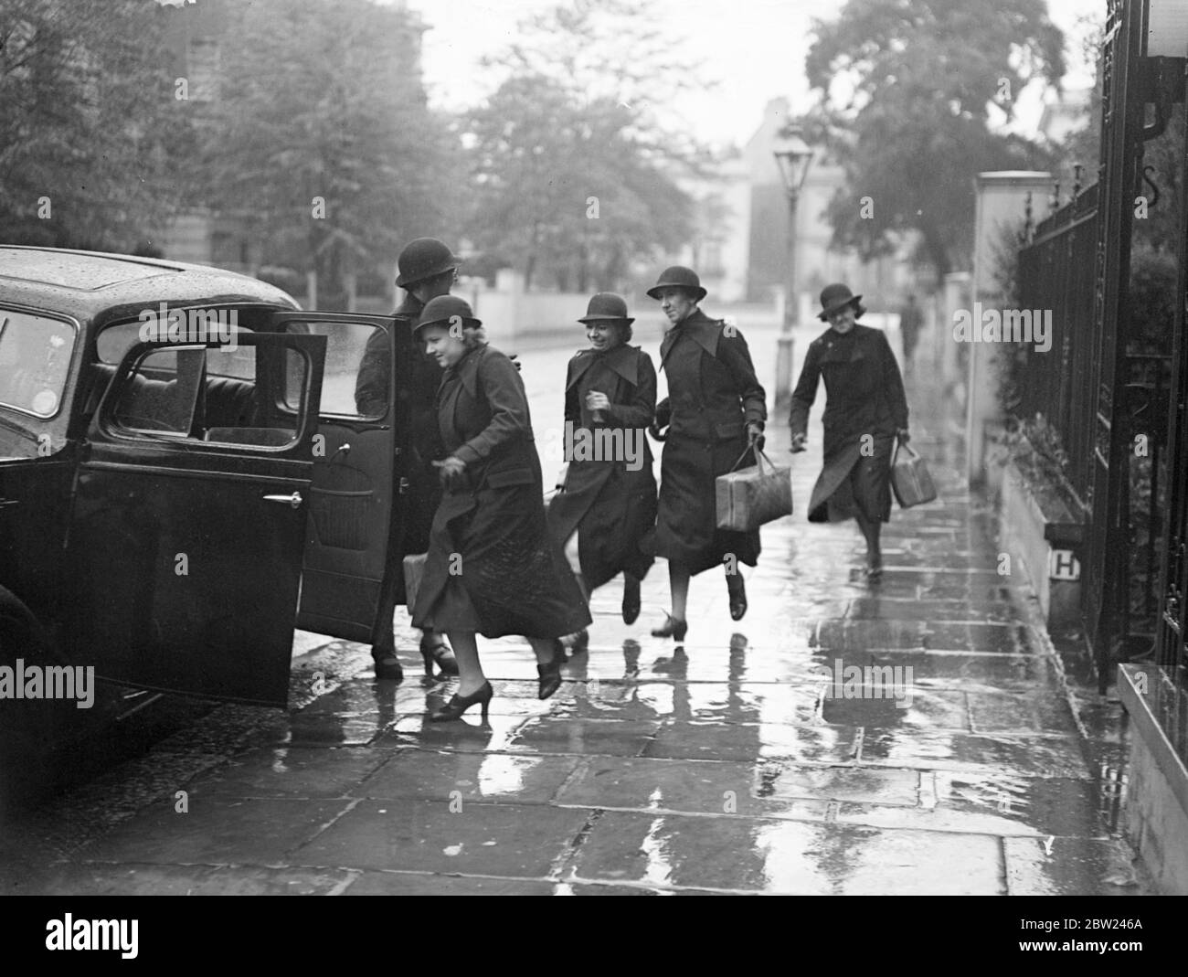 London hat eine weitere fliegende Truppe, um den Tod statt Verbrechen zu bekämpfen. Tag und Nacht, Krankenschwestern im Dienst in einer Klinik Pembridge Place, Bayswater, bereit, zu verlassen, um sofort bemerkt, einen Ruf um Hilfe zu beantworten. Die Krankenschwestern, die ihr Kit fertig verpackt und Autos stehen vorbei, sind bereit, mit allem, von einem verstauchten Knöchel zu einem Mutterschaftskoffer zu bewältigen. Foto zeigt: Krankenschwestern laufen zum Anruf, um einen Notruf anzunehmen. Oktober 1938 Stockfoto