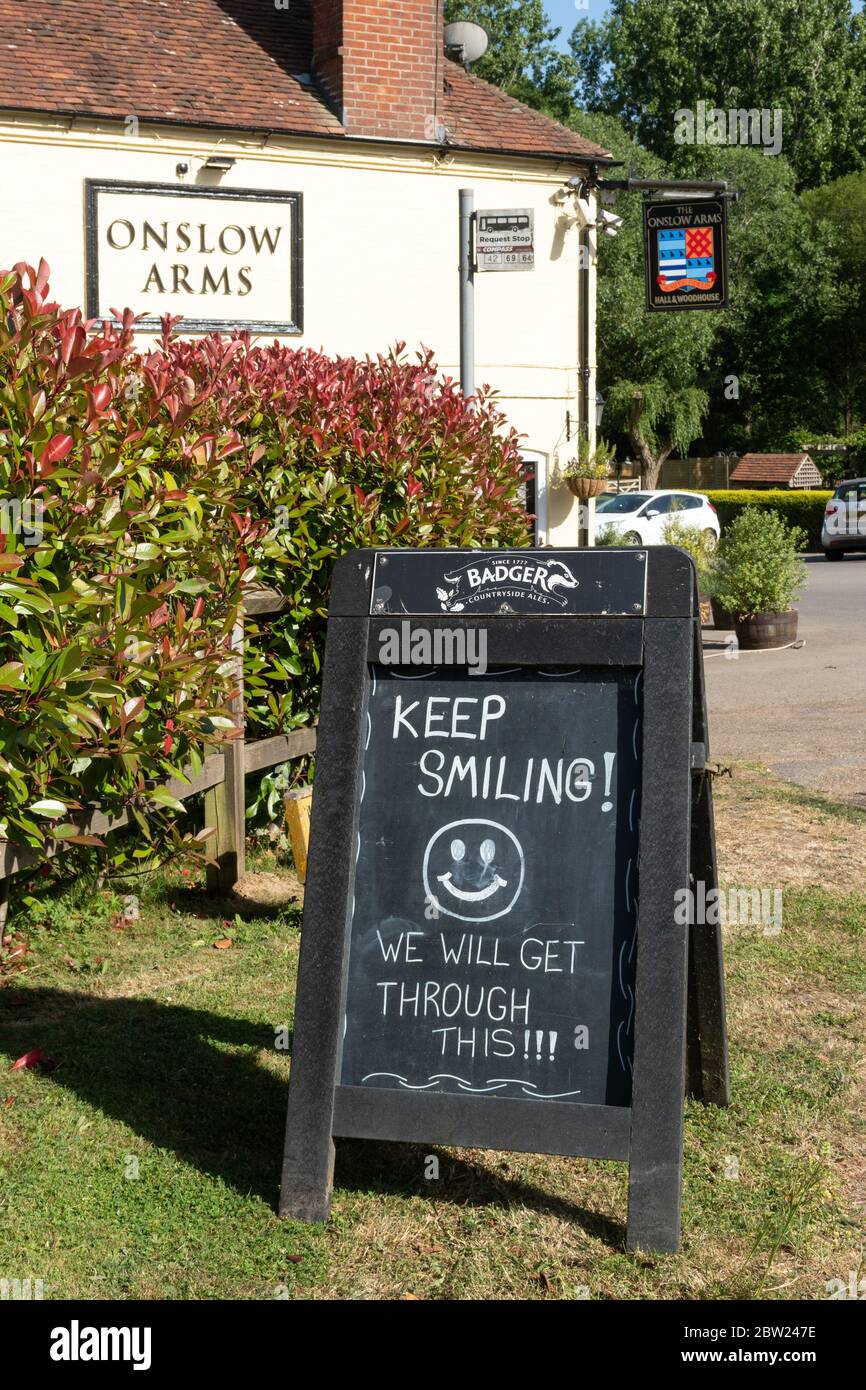 Schild vor dem Onslow Arms Pub sagen, halten Lächeln Wir werden durch das! Während der Coronavirus Covid-19 Pandemie, Loxwood, West Sussex, Großbritannien Stockfoto