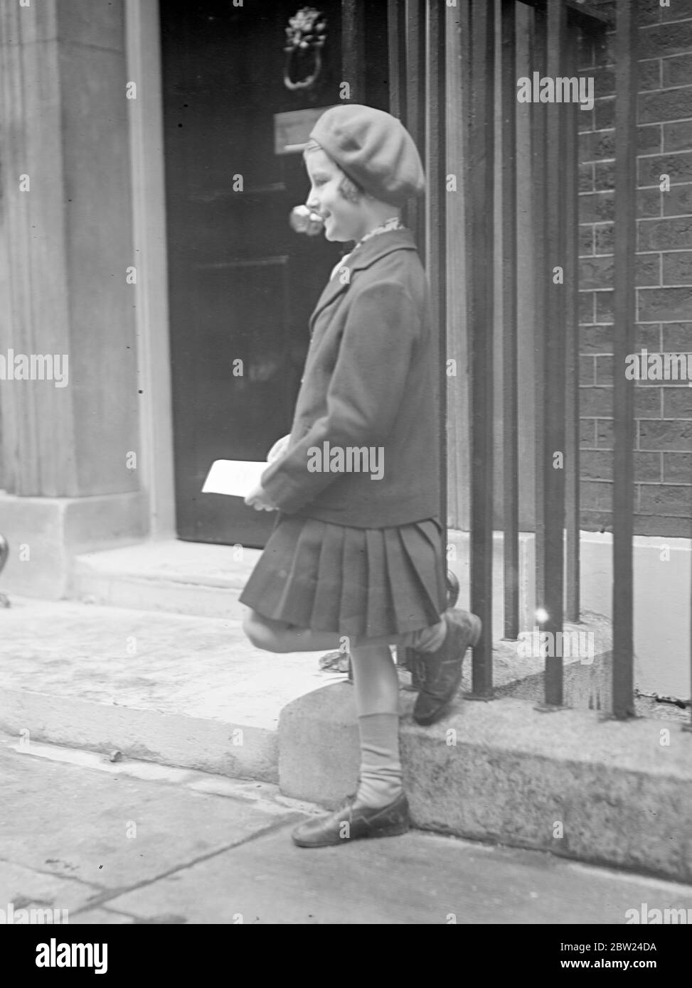 Dorothy, sieben Jahre alt, wartet außerhalb Nr. 10, um Brief an Frau Chamberlain zu übergeben. In der Downing Street 10 erhalten Neville Chamberlain und seine Frau Hunderte Dankesbotschaften und Glückwünsche. Ein kleines Mädchen, Dorothy Friend, 7 Jahre alt, wartete vor Nr. 10, um Frau Chamberlain persönlich ihren Brief zu übergeben. Oktober 1938 Stockfoto