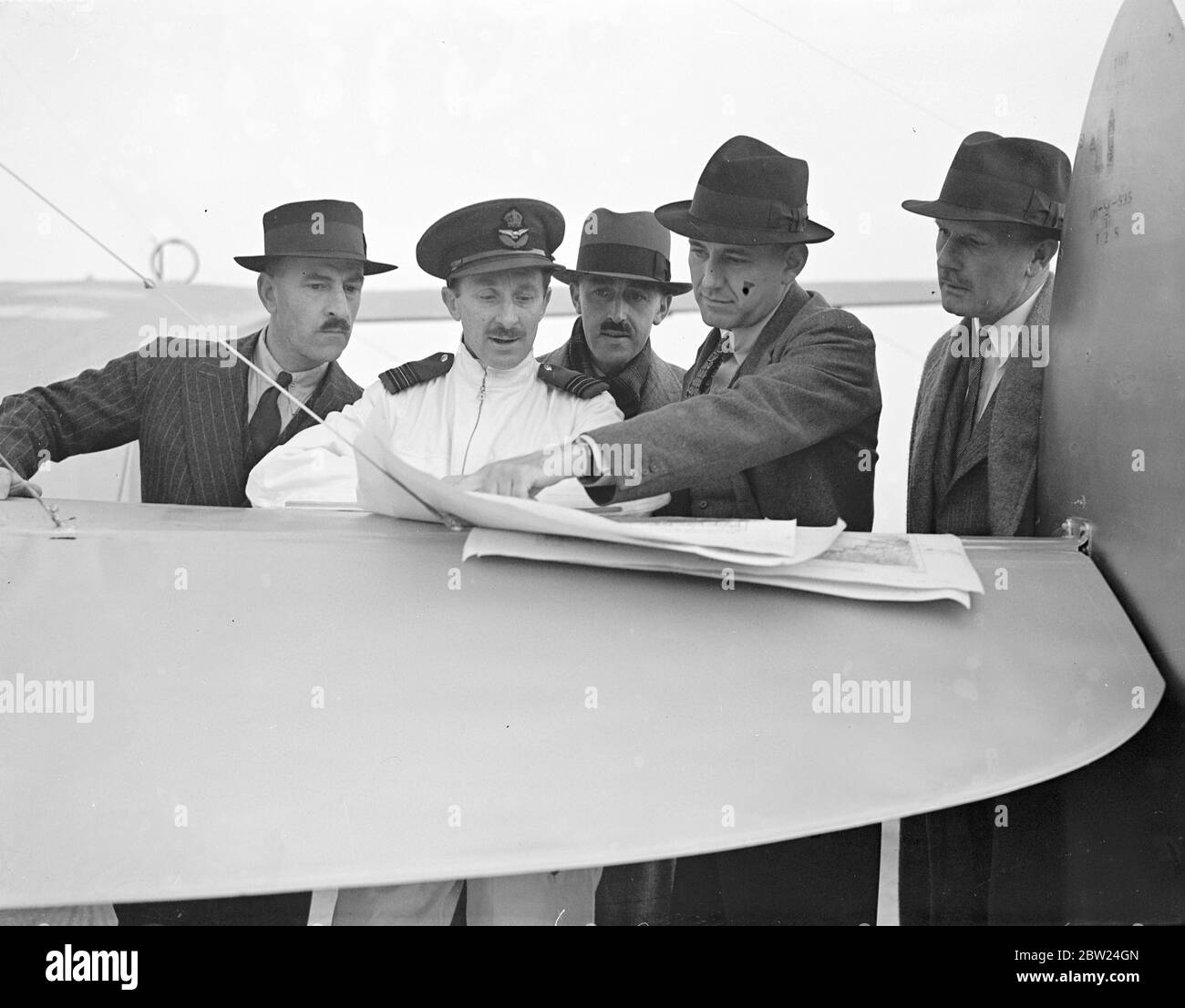 Air Undersekretär, verlässt auf Tour der RAF-Einheiten in Übersee. Capt H Balfour, der Staatssekretär für Luft, verließ Hendon Aerodrome, um Einheiten der Royal Air Force in Ägypten, Sudan, Kenia, Palästina, Transjordan, Irak und Malta zu besuchen. Er wird begleitet von Group Capt W A Coryton, stellvertretender Direktor für Überseeoperationen, Mr. F. R. Howard vom Luftministerium und Captain EC Cobb, MP, Parlamentarischer Staatssekretär. Der erste Halt der Party war Rom. Foto zeigt, Kapitän Balfour, der seine Route auf einer Karte mit Mitgliedern seiner Partei und der Chef-Pilot, als sie waren, um Hendon zu verlassen, links Stockfoto