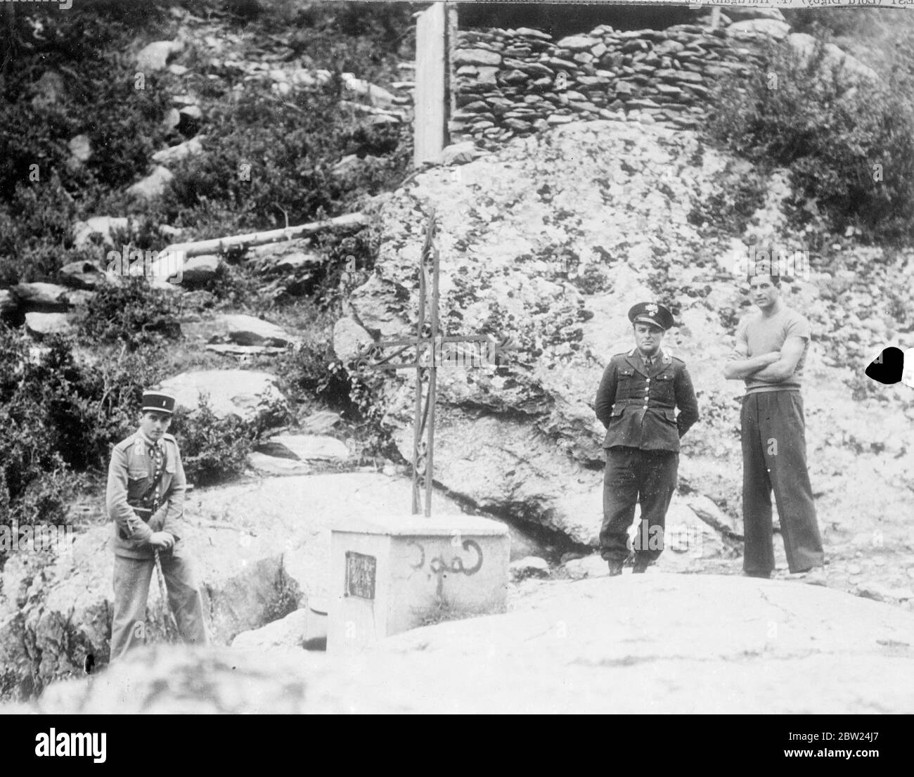 Ein italienischer Grenzposten (links) und ein französischer Gendarm an einem Grenzstein an der Grenze zwischen Italien und Frankreich, nur wenige Schritte von Isola, dem französischen Dorf auf italienischem Gebiet, entfernt. Die französische Kolonie hat eine kurze Zeit der Gnade gewährt und versucht, in die Ernte zu bekommen, bevor sie es verlässt. Die Warnung auf dem Stein im Bild droht die Verhaftung von jedem, der die Grenze überquert. 10. September 1938 Stockfoto