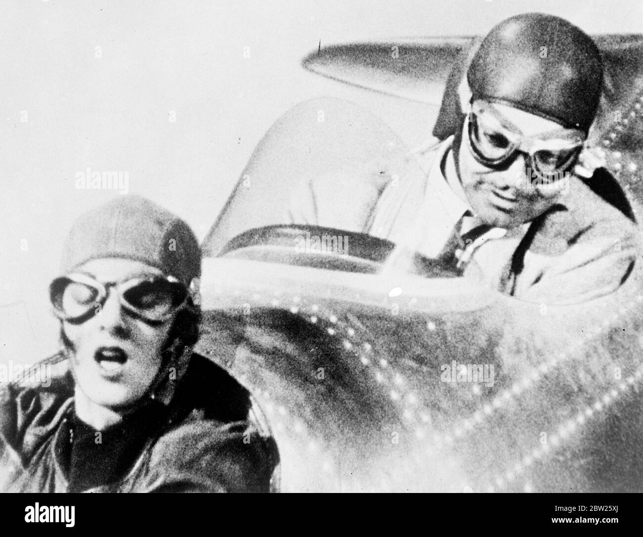 Luftwerbung, auf der Studioetage. Diese Bilderserie zeigt die Wirbelwind-Balz im Cockpit eines Flugzeugs von Myrna Loy und Clark Gable, wagemutiger Testpilot, stellt sich Myrna Loy vor, als er gezwungen ist, auf einem Feld zu landen. Das Flugzeug soll eine Meile hoch sein, da Gable Myrna Loy eine Flugstunde gibt, aber die Aufnahmen wurden in einer speziellen Maschine auf dem Studioboden gemacht. Foto zeigt, Myrna Loy gibt eine große Arbeit der Erleichterung, wie Gable zieht das Flugzeug aus dem Tauchgang. Stockfoto