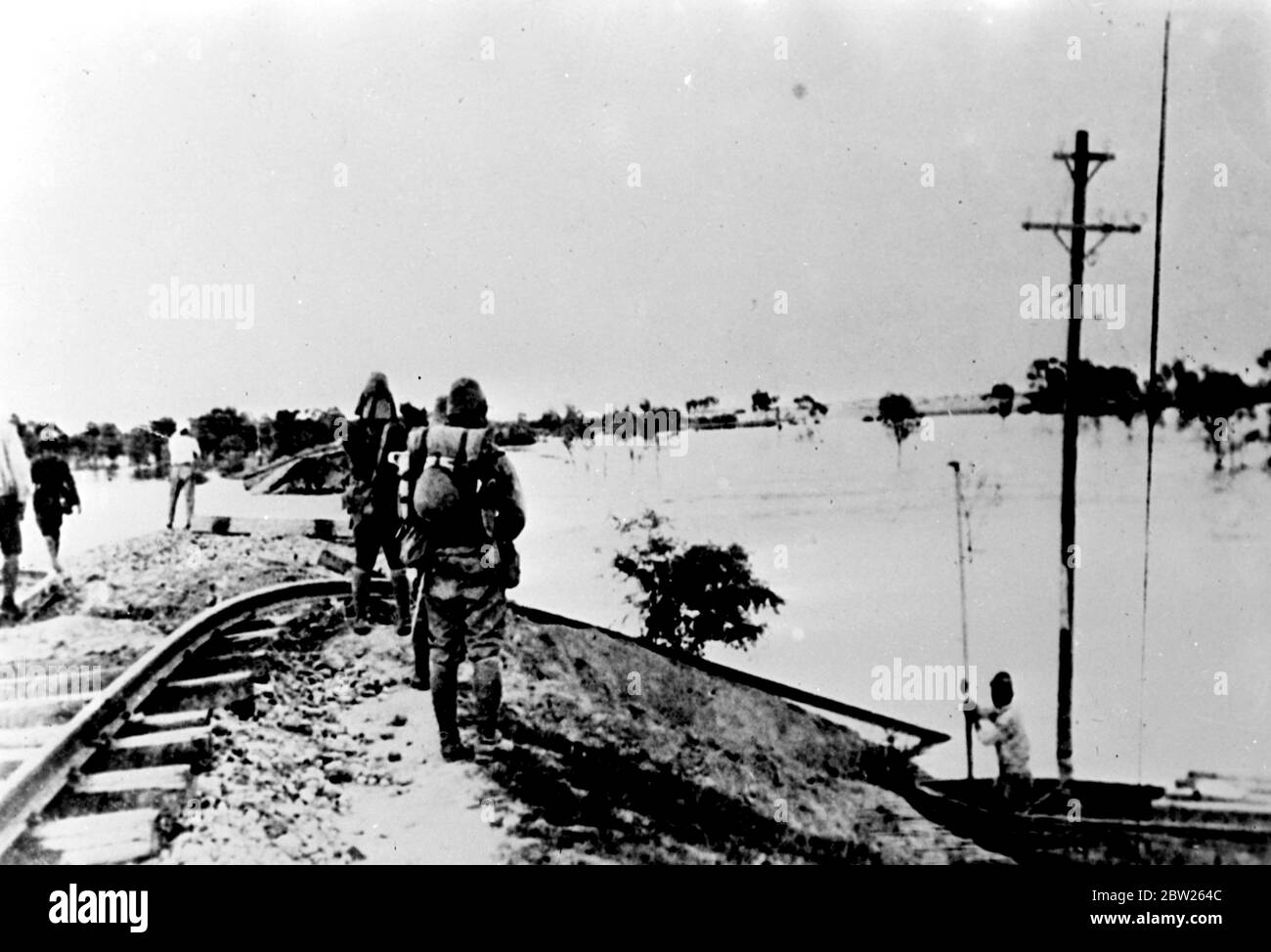 Gelber Fluss Überschwemmungen Schäden Lunghai Railway. Die Lunghai-Bahn, die das Zentrum der Kämpfe zwischen chinesischen und japanischen Kräften war, wurde durch die Fluten des Gelben Flusses beschädigt, die weite Gebiete überschwemmten und China Tod und Zerstörung brachten, leidet bereits Millionen. Foto zeigt, Soldaten sehen Schäden durch die Fluten des Gelben Flusses an der Lunghai Eisenbahn in der Nähe von Kaifeng. 13 Juli 1938 Stockfoto