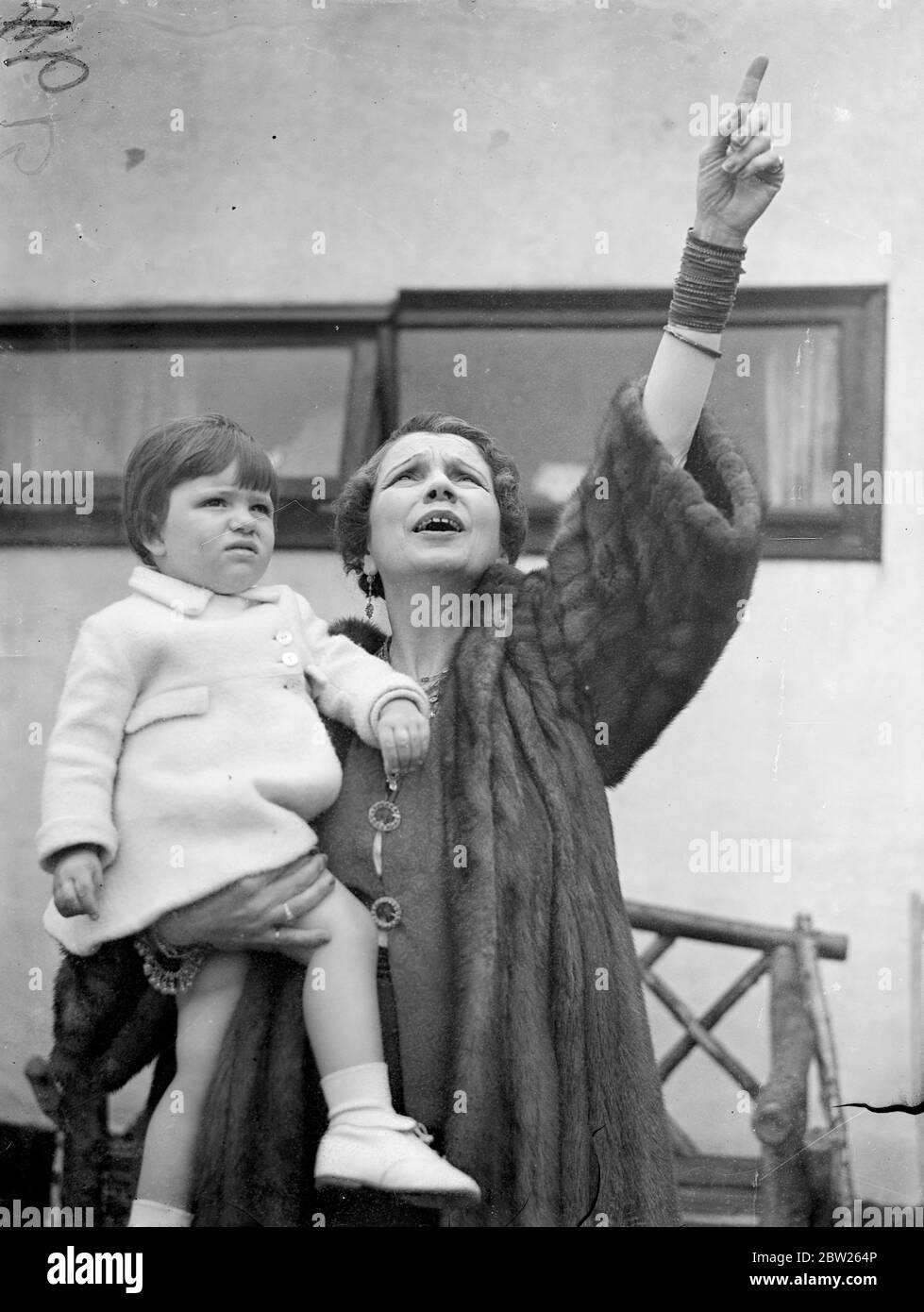 Ranee von Sarawak zeigt Grand Daughter die Flugzeuge bei 'All Women's Pilot's Dislay'. Starker Regen spülte einen Teil der ersten 'All Women Pilots'-Ausstellung aus, die im Romford Aerodrome, Essex, gezeigt wurde, als prominente britische und kontinentale Flugerinnen Ausstellungen hielten. Die Ausstellung wurde zugunsten des Romford Flying Club, der über eine Mitgliedschaft von mehr als 200 Mädchen verfügt, gegeben. Foto zeigt, die Ranee von Sarawak zeigt die Flugzeuge Roberta, ihre Enkelin. Roberta ist die Tochter von Harry Roy, dem Bandleader, und Princcess Pearl. Juli 1938 Stockfoto