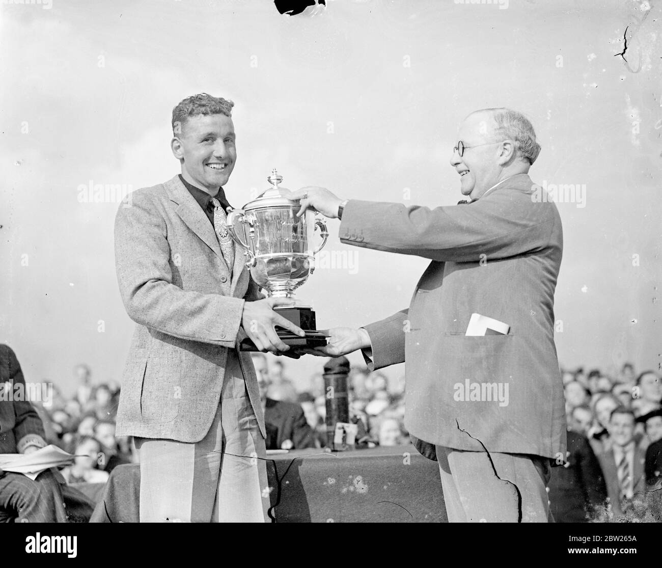 Henshaw erhält Trophäe von Air Minister nach dem Gewinn des King's Cup Race. Alex Henshaw, der in den ersten zehn Runden 236 Meilen pro Stunde zurückgelegt hatte, gewann das King's Cup Air Race in seinem Percival New Gul Flugzeug und erhielt die Trophäe von Sir Kingsley Wood, dem Air Minister. Die Strecke war über 1,000 Meilen, Start und Ziel in Hatfield. Foto zeigt, Alex Henshaw erhält die Trophäe von Sir Kingsley Wood nach seinem Sieg. Juli 1938 Stockfoto